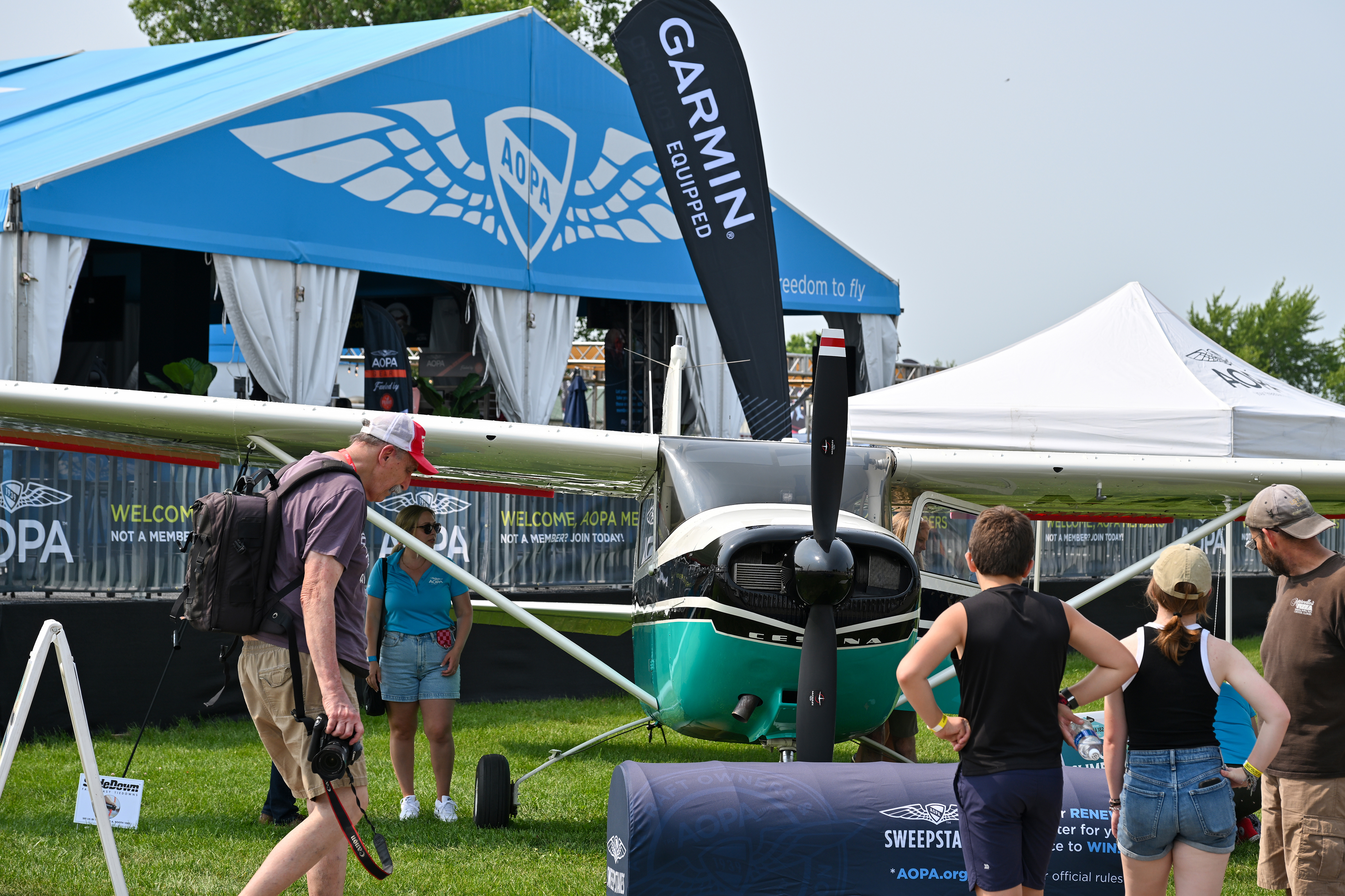 Attendees admire the AOPA Sweepstakes Cessna 182 during EAA AirVenture Oshkosh. Photo by David Tulis.