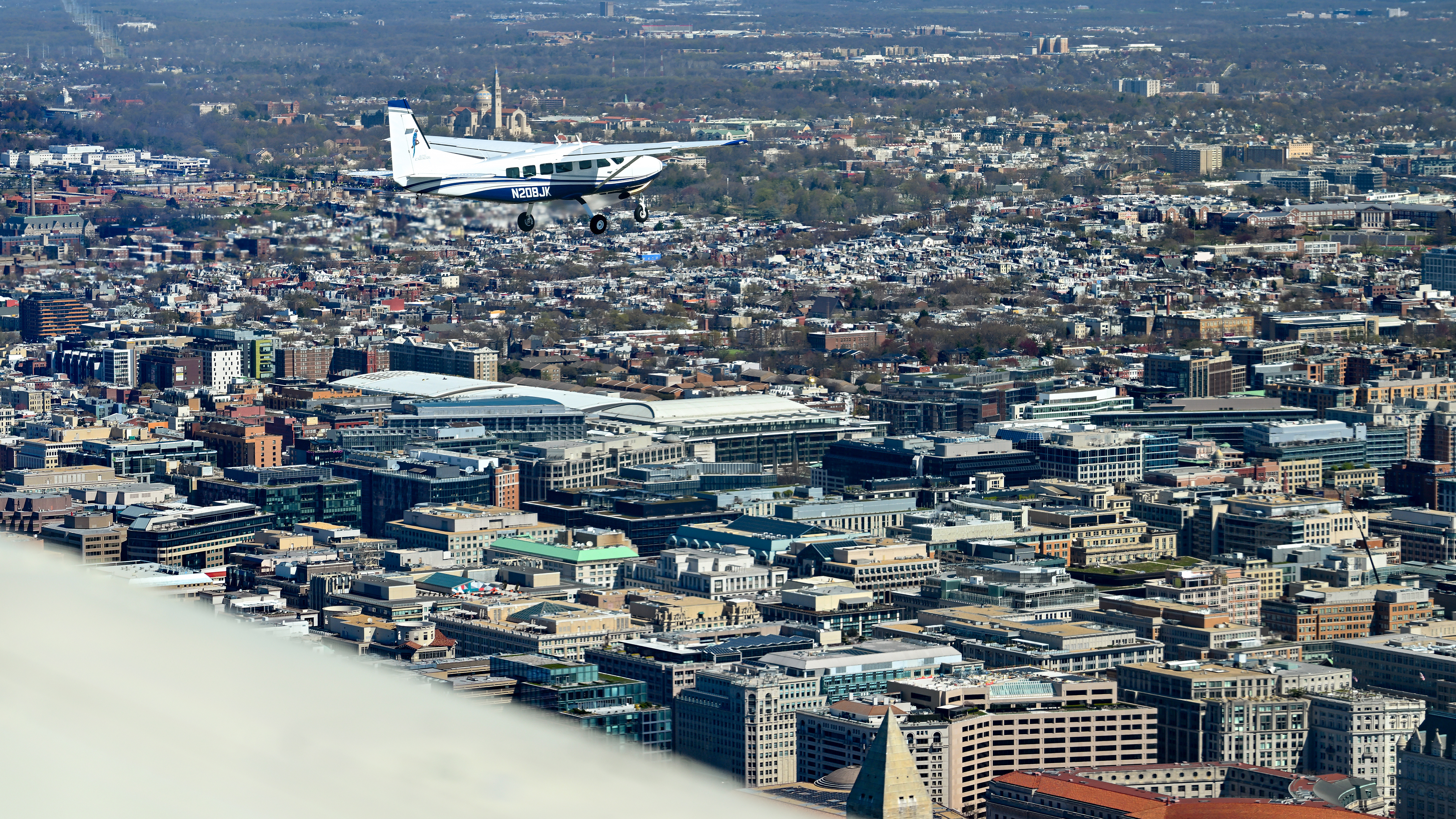 Washington Flyover Practice - a Cessna Caravan flies past the Washington Monument.