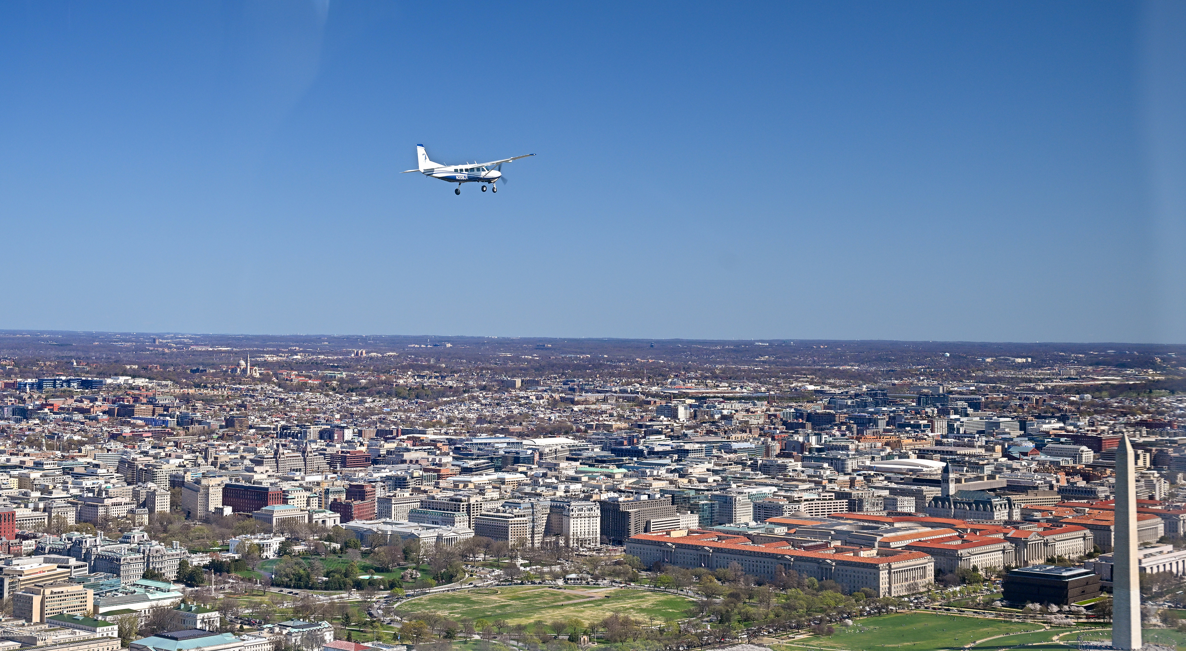 The Washington Monument, lower right, passes below a Cessna 208 Caravan piloted by AOPA President Mark Baker. Photo by David Tulis.