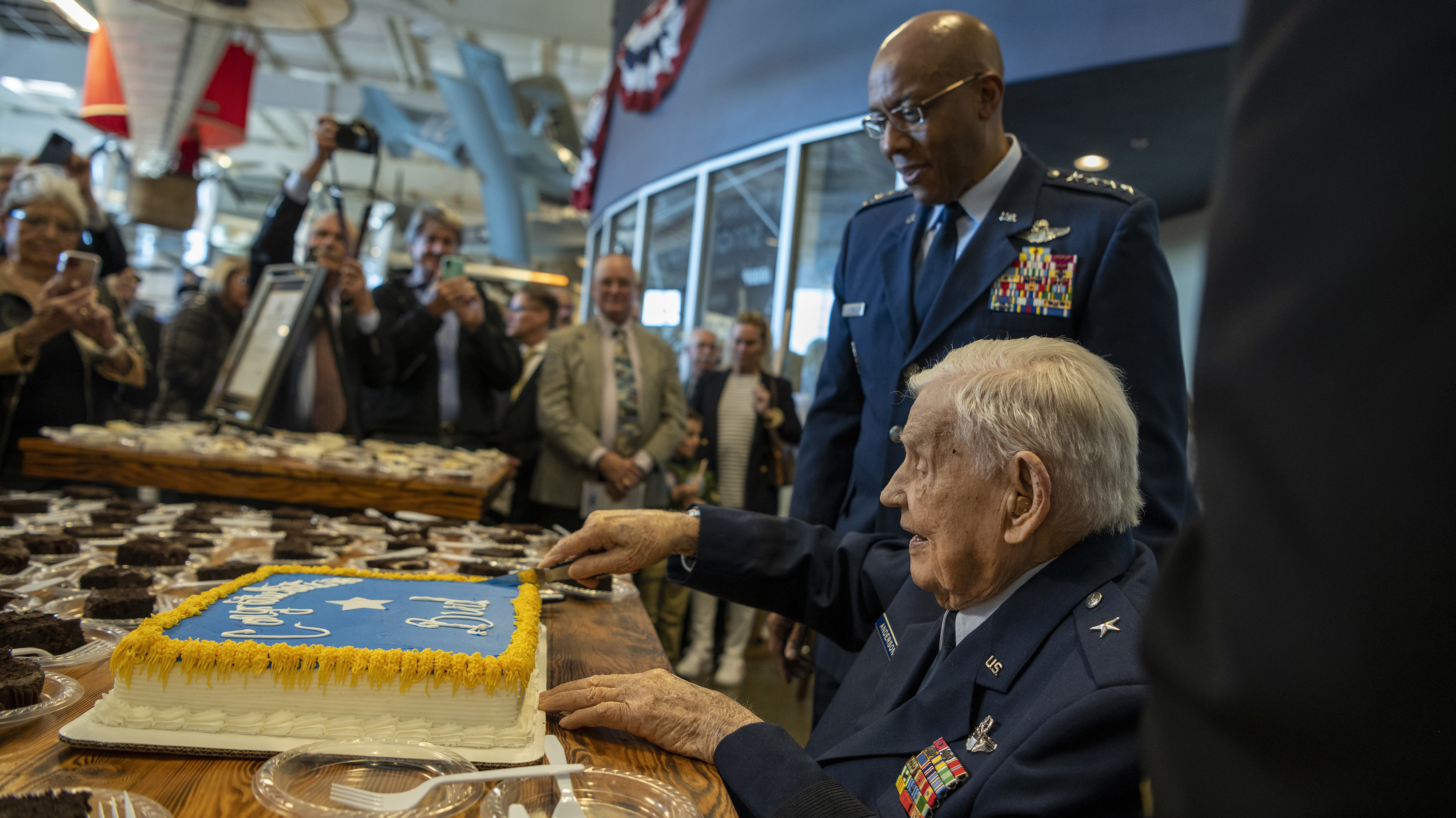 Retired Brig. Gen. Clarence E. 'Bud' Anderson cuts a celebratory cake after an honorary promotion ceremony presided over by U.S. Air Force Chief of Staff Gen. CQ Brown, Jr. at the Aerospace Museum of California in McClellan, California, December 2, 2022. The ceremony was an opportunity to honor the 100-year-old World War II triple ace during the seventy-fifth anniversary year of the Air Force’s establishment as a military service. U.S. Air Force photo by Nicholas Pilch.