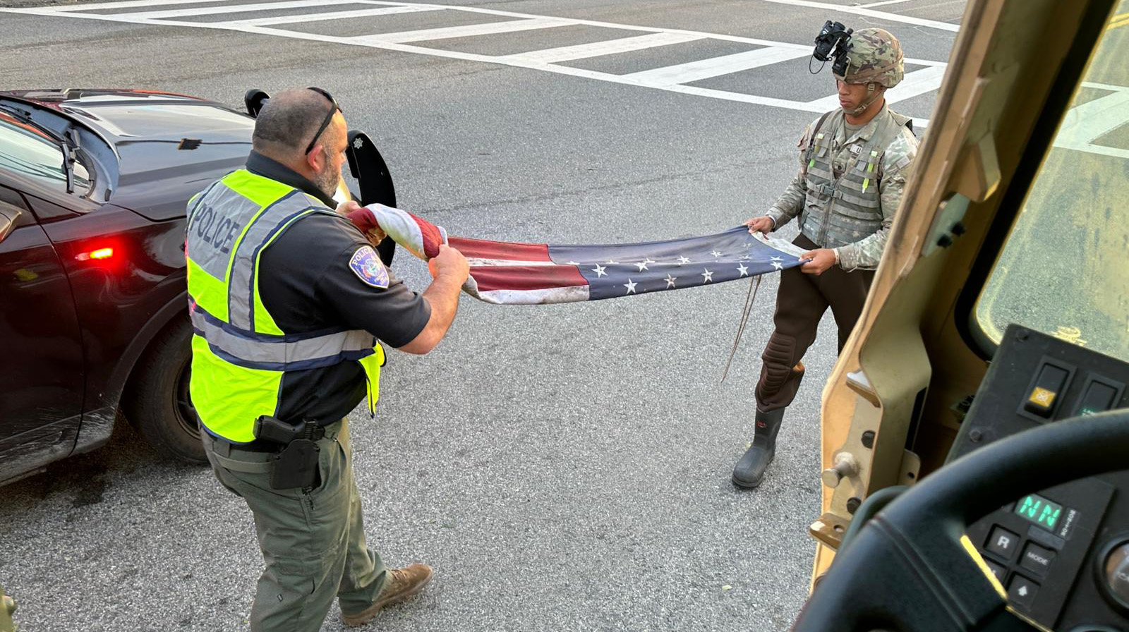 Florida Army National Guard Spc. Trent Murphy folds a U.S. flag with a local first responder during the response to Hurricane Milton in Bradenton, Florida, October 10. U.S. Army National Guard photo by Staff Sgt. Cesar Rivas.