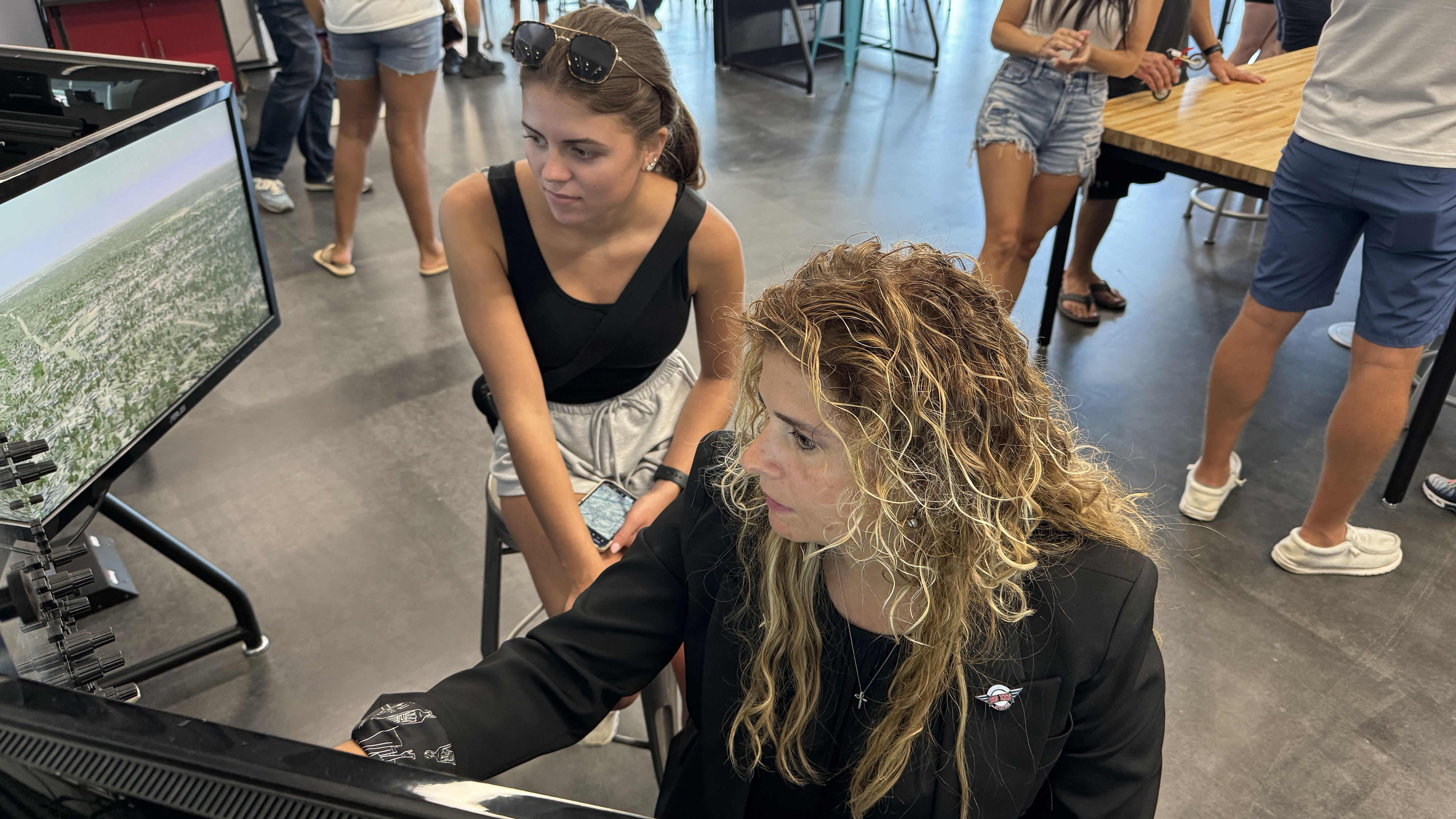 Natalie Campana, a STEM teacher at Steubenville High School in Steubenville, Ohio, sits at a simulator with Leah Amaismeier, a high school graduate of the program, and now a flight student at Pier Aviation at Jefferson County Airport in Ohio. Photo by Glenn Ponas.