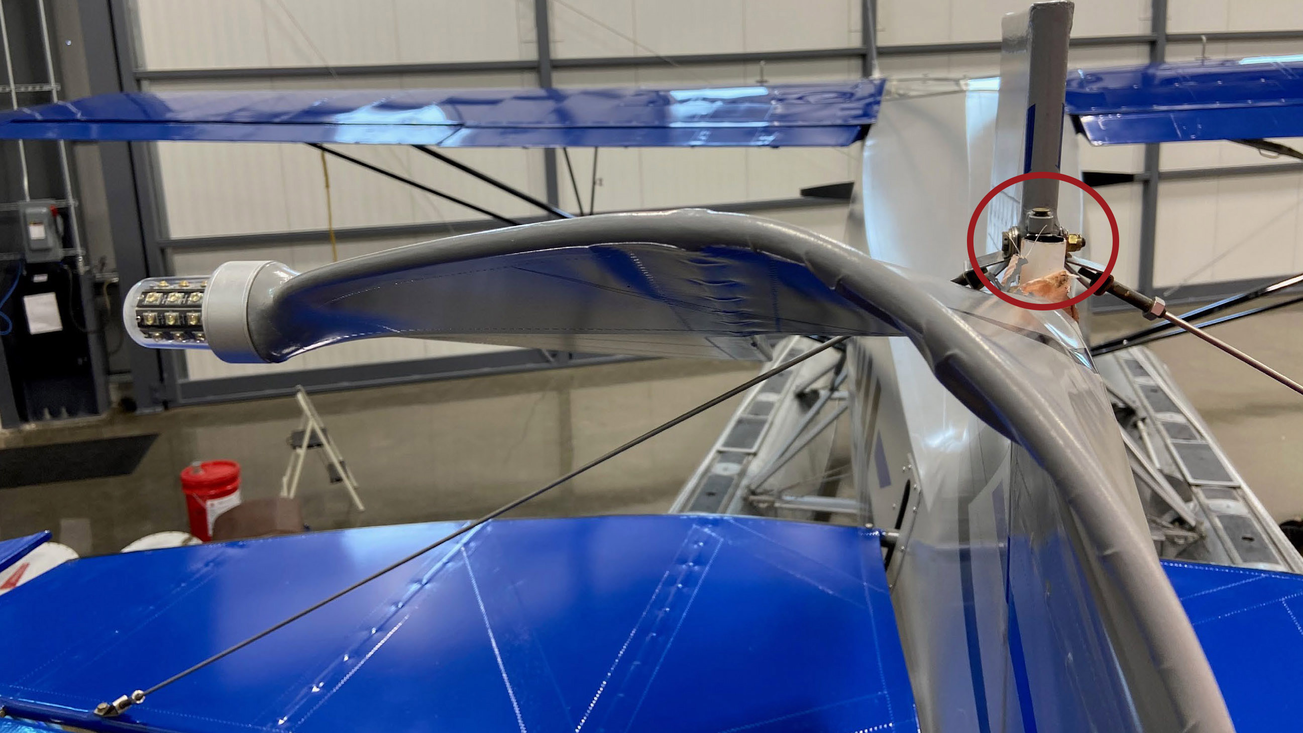 A Piper PA–12 on floats became nearly impossible to control after the airplane's rudder post fractured above the upper hinge (circled) on June 8, 2020, causing the top of the rudder to fold over in flight. NTSB photo.