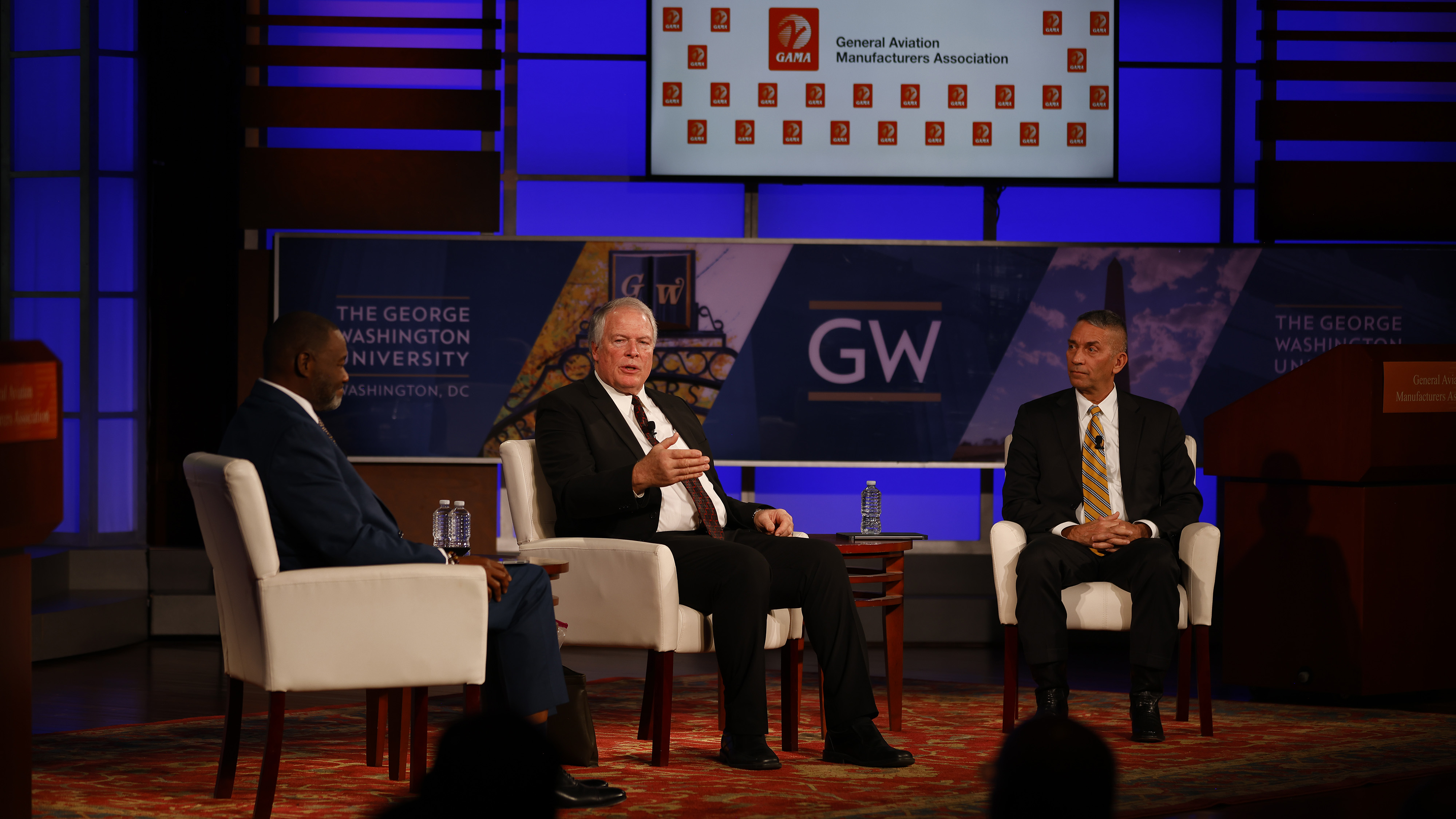 Longtime GAMA president and CEO Pete Bunce, center, discussed the industry outlook with incoming GAMA president James Viola, right, and Chairman Henry Brooks, an executive with Collins Aerospace. Photo by Rebecca Boone.