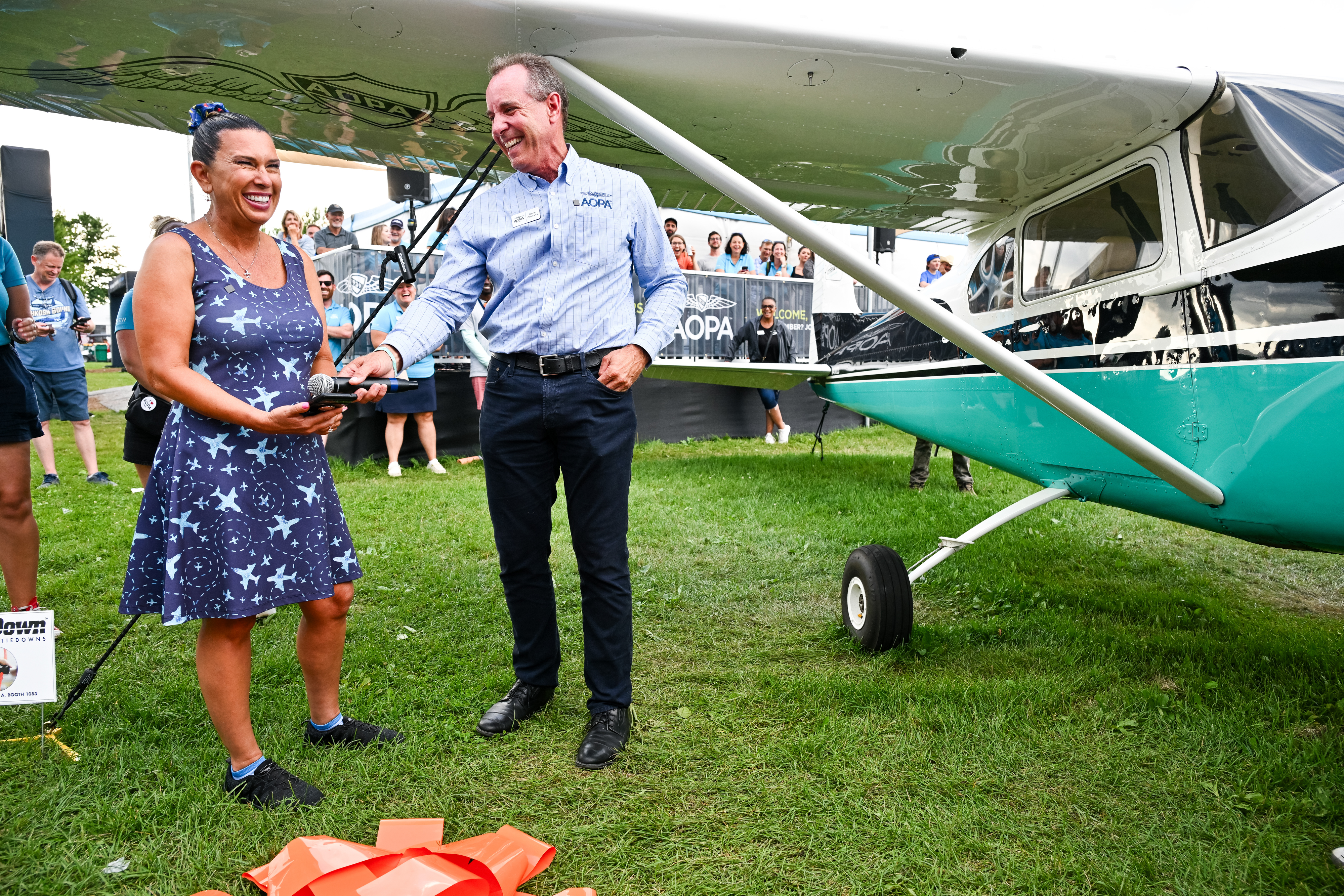 Jennifer Hortman, a California pilot and 30-year AOPA member who funded advanced ratings to improve her aviation skills, calls her husband after winning the 1958 AOPA Sweepstakes Cessna 182 aircraft presented to her by AOPA President Darren Pleasance. Photo by David Tulis.