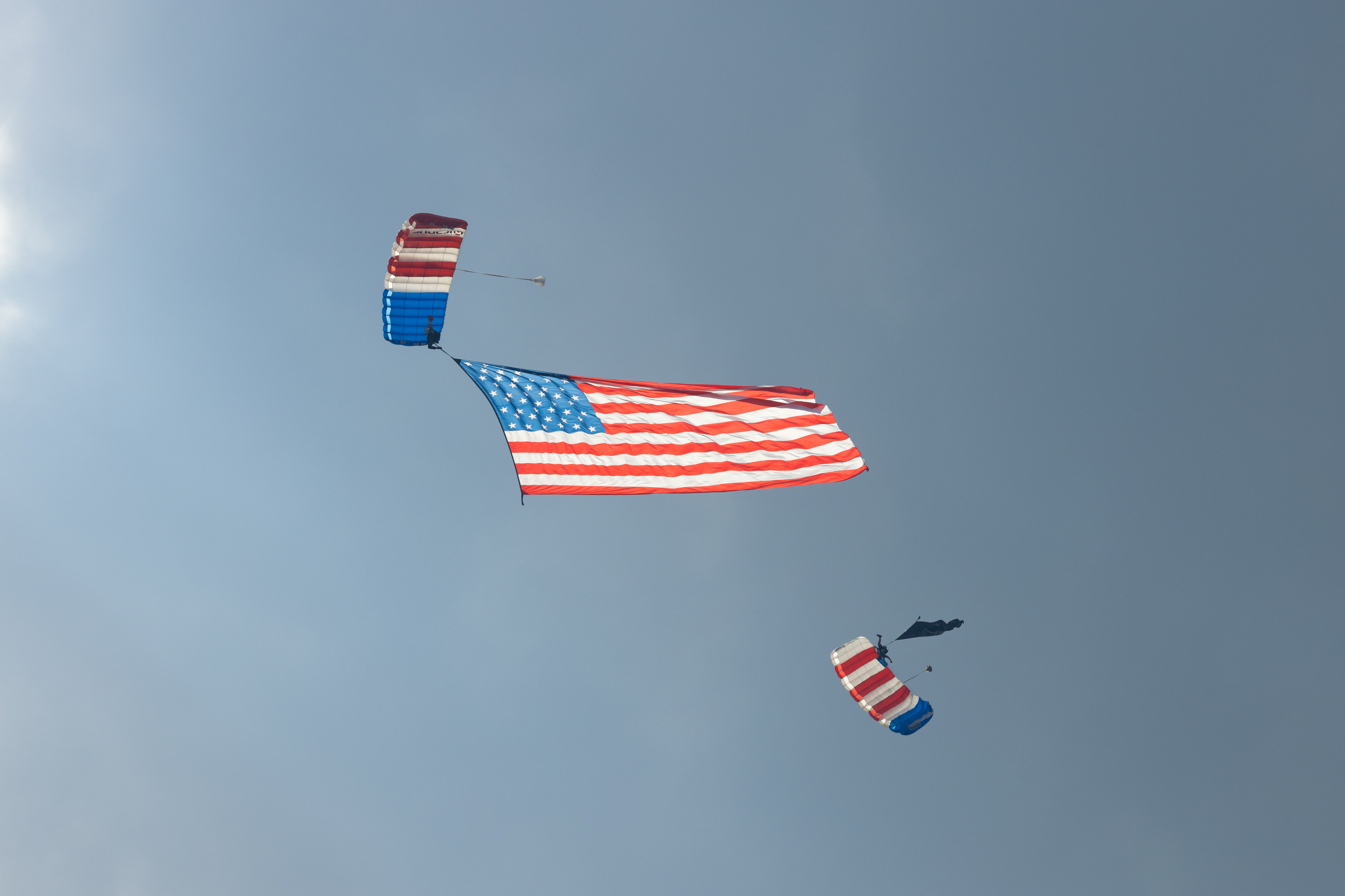 Parachutists carry the American flag during the airshow. Photo by Rebecca Boone.