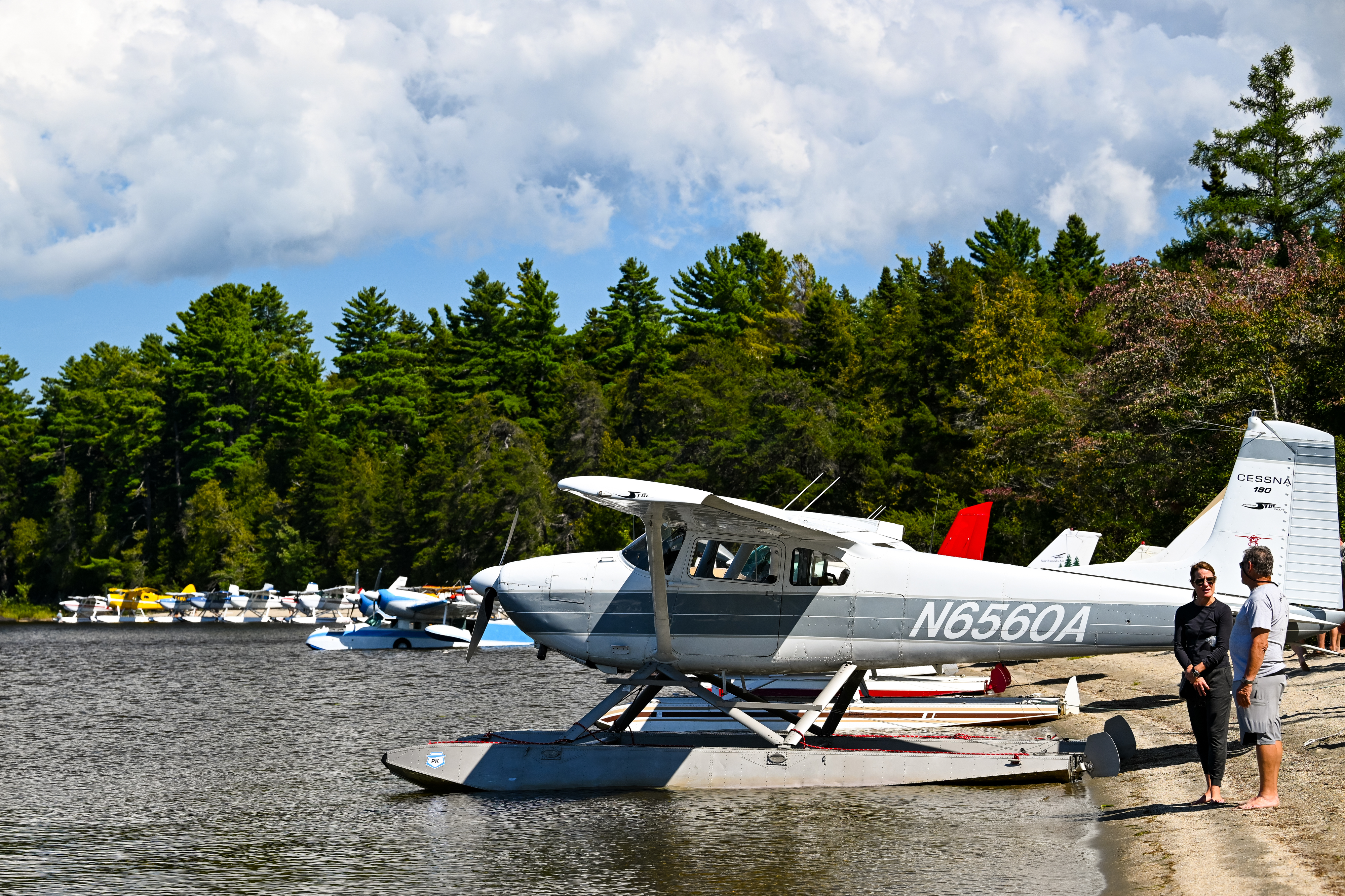 Central Maine Aviation seaplane instructor Erin Coulter's Cessna 180 on straight floats joins 36 other seaplane pilots on "Little Claw" beach for a fly-out and lunch cookout at Lobster Lake. Photo by David Tulis.