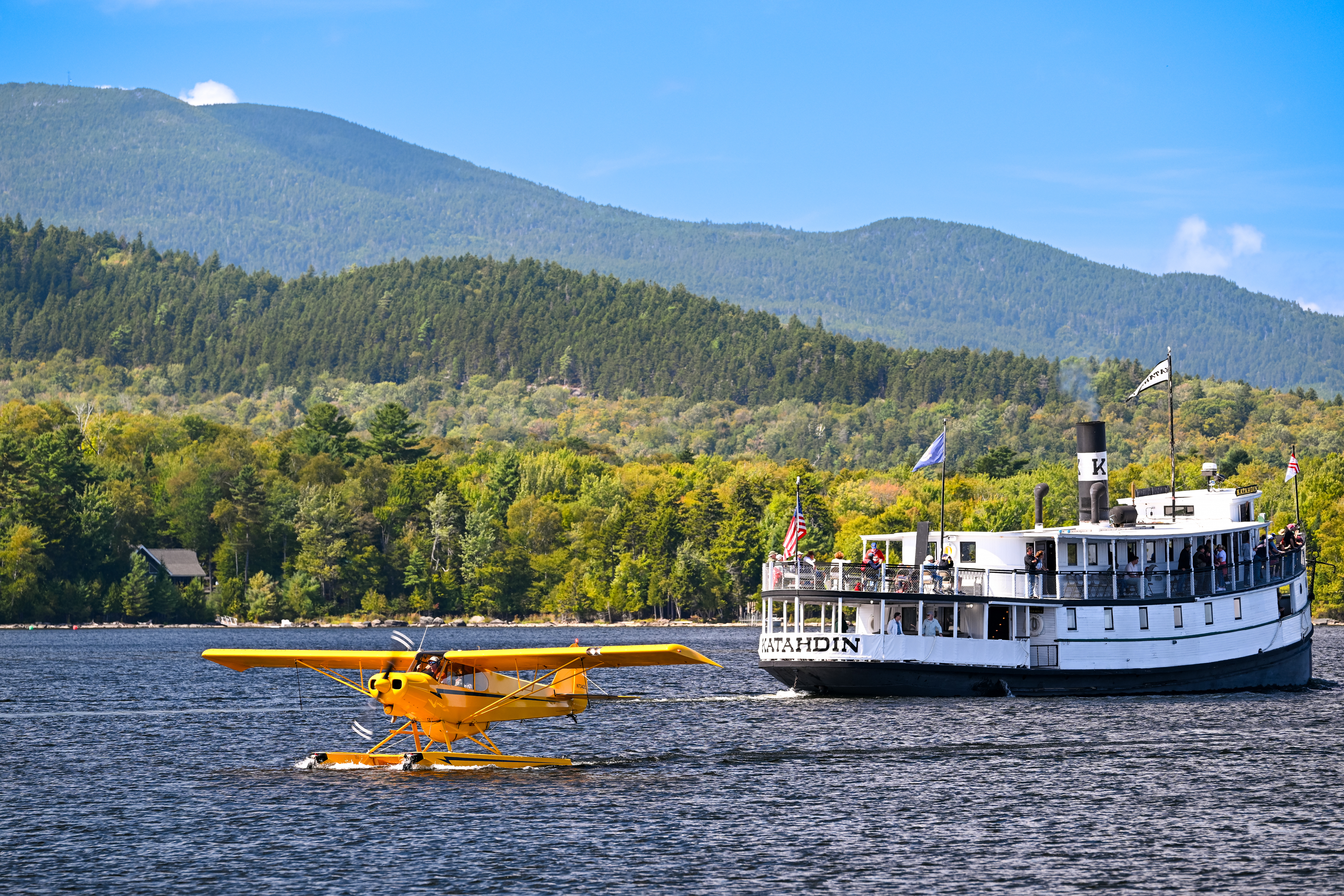 The steamboat "Katahdin," also known as "The Kate," plies the waters of Moosehead Lake near a Super Cub on floats water taxiing to the dock. The ship offers a glimpse into the glory days of steam boating and is on the National Register of Historic Places. It was recently restored after a $2 million fundraising effort. Photo by David Tulis.
