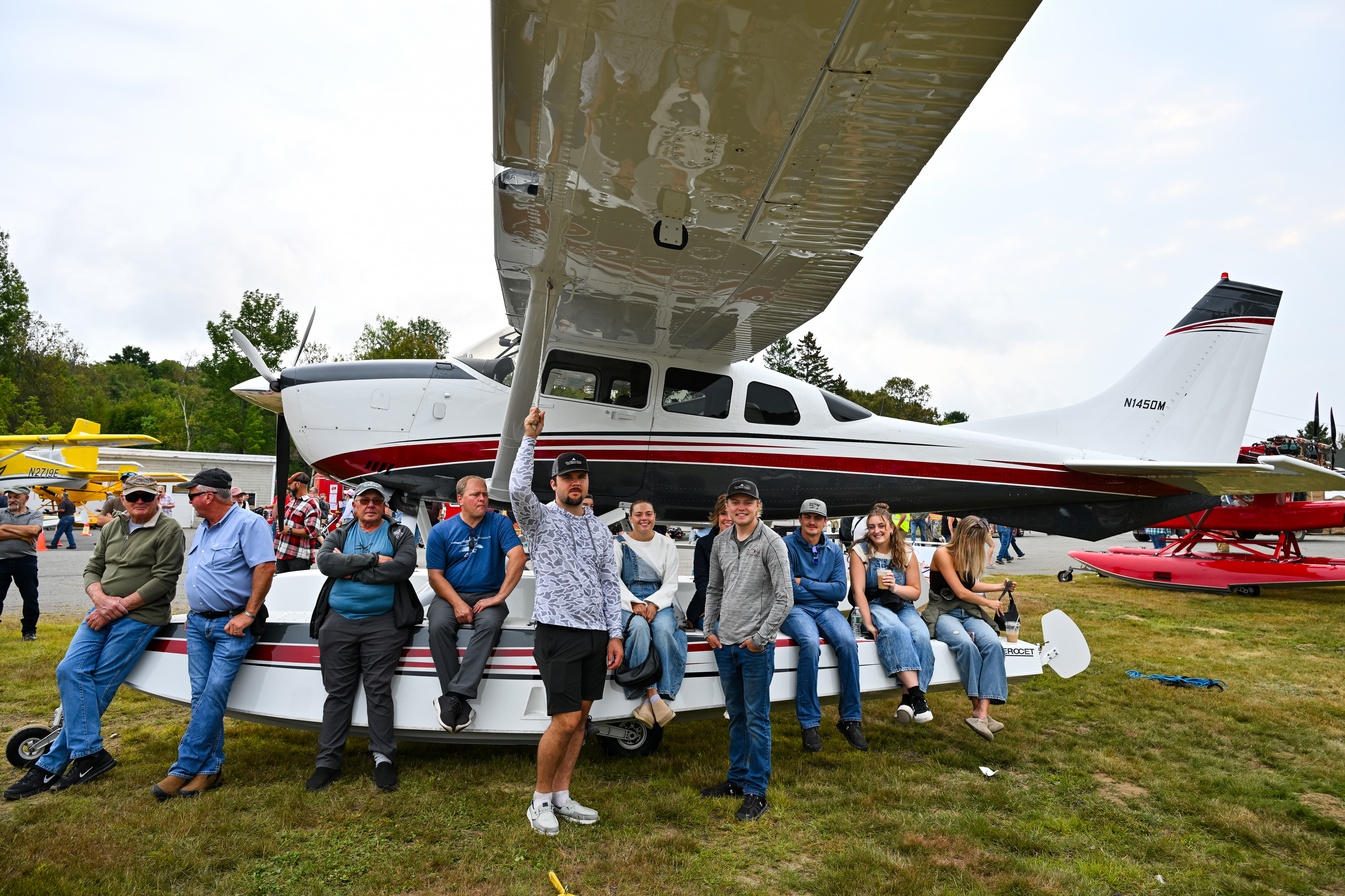 Attendees crowd onto a Cessna 206 Skywagon on amphibious floats to watch a water parade of aircraft. Photo by David Tulis.