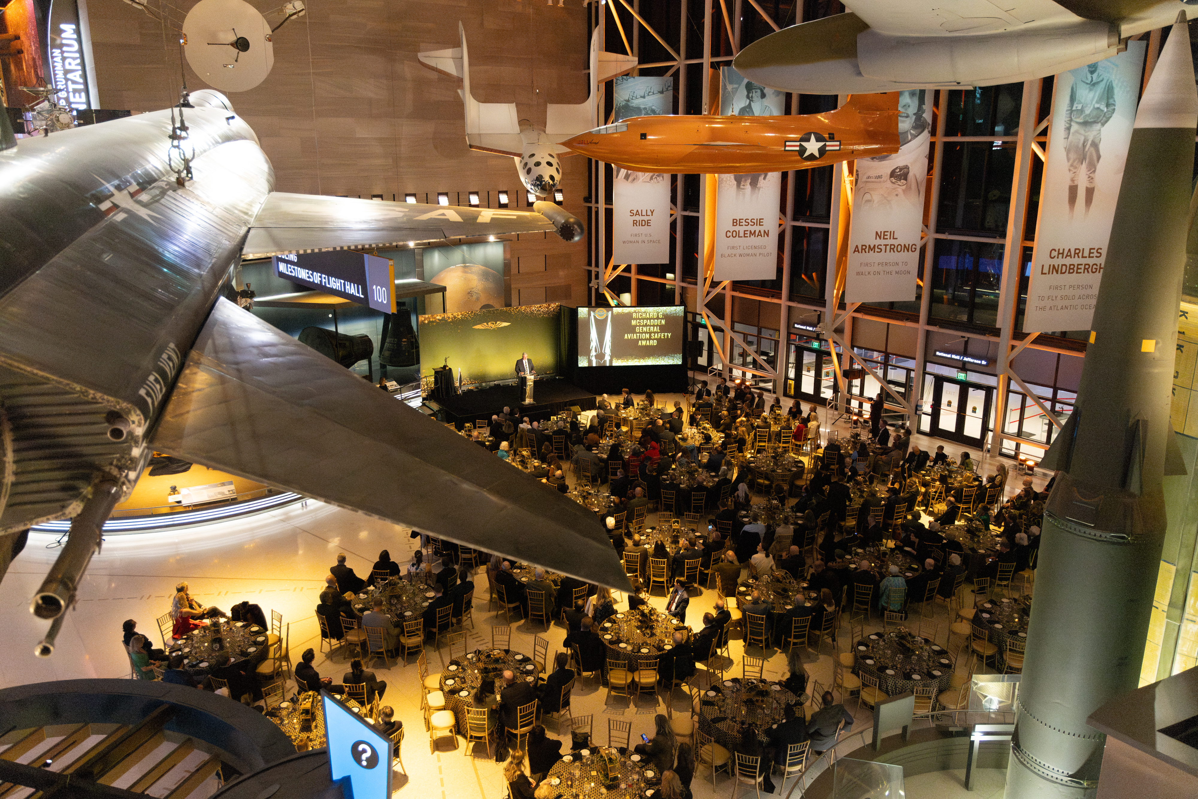 AOPA Air Safety Institute Senior Vice President Mike Ginter addressed the large crowd beneath the beautiful aircraft on display at the museum. Photo by Rebecca Boone.
