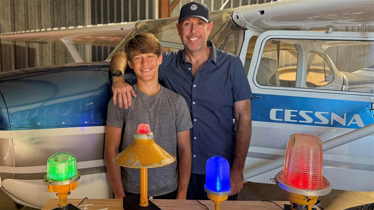 Joe and Joe North stand behind a table of METAR Lightworks lamps. What was originally a Father’s Day present has grown into a father‑and‑son project bridging aviation weather data and general aviation flying. Photo courtesy of Joe North.