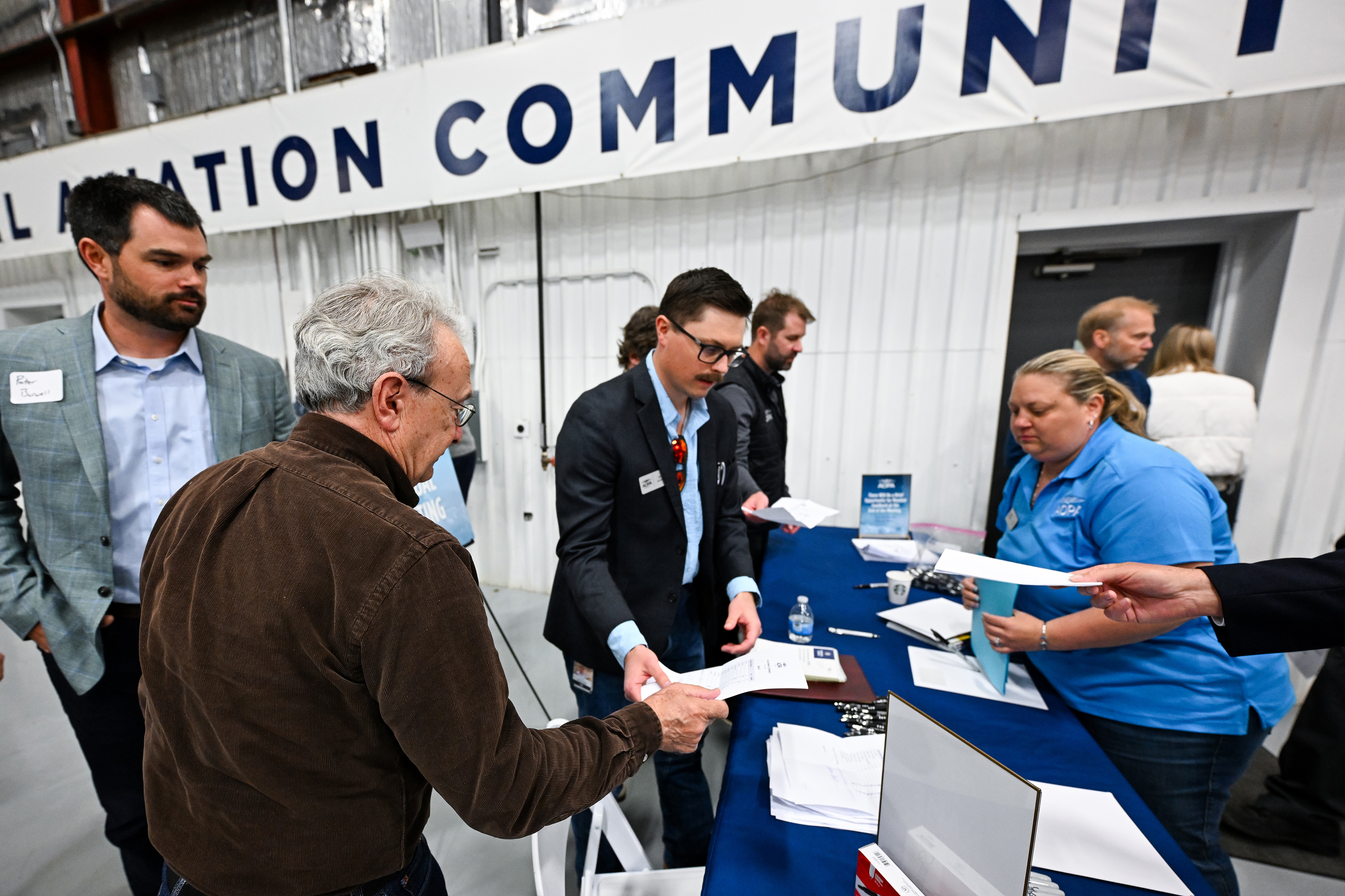AOPA members including new trustee Peter Burwell (left rear) hand in their ballots electing 11 trustees. Photo by David Tulis.
