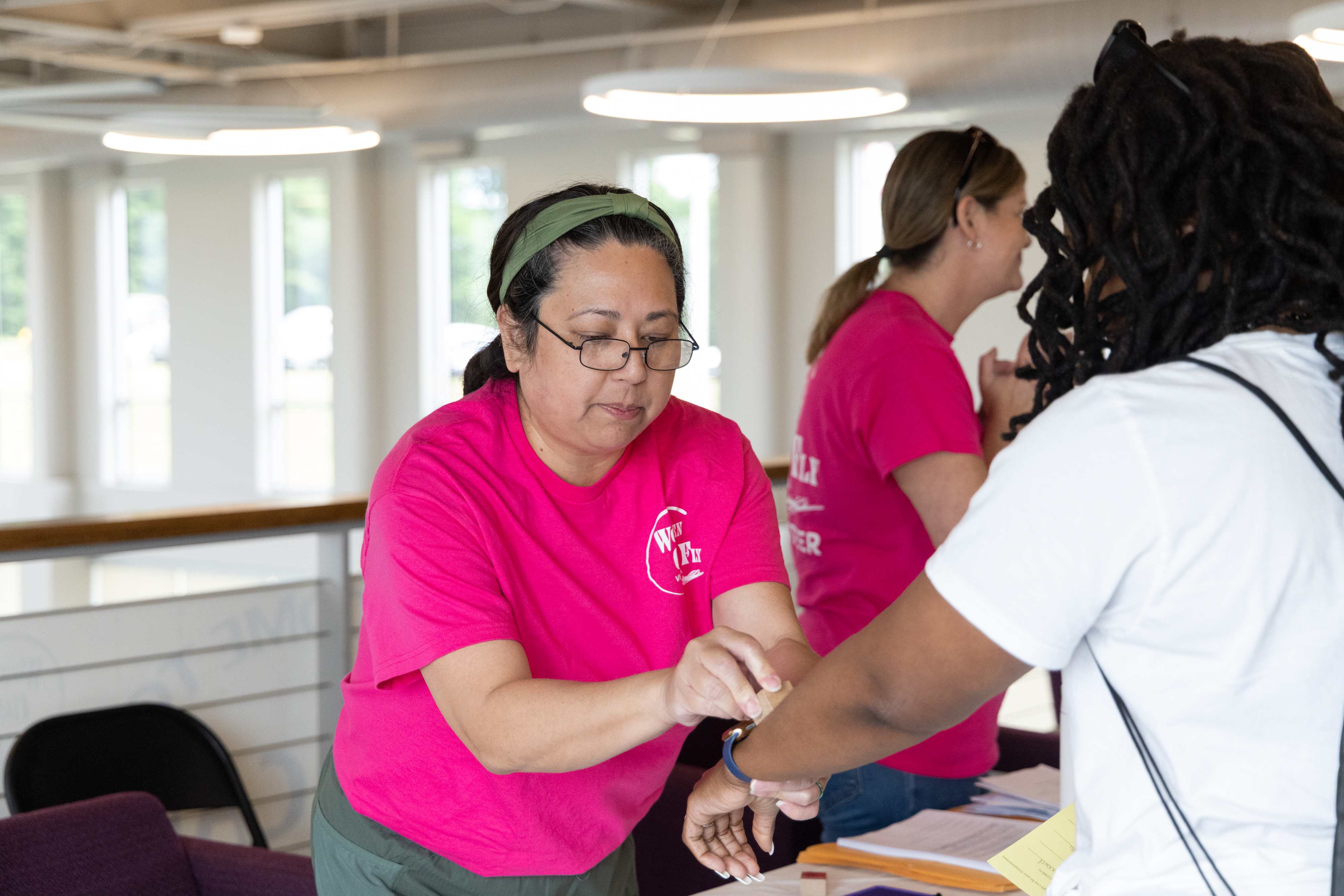 A volunteer stamps an attendee’s hand after her preflight briefing, indicating her preparedness for her first flight. Photo by Rebecca Boone.