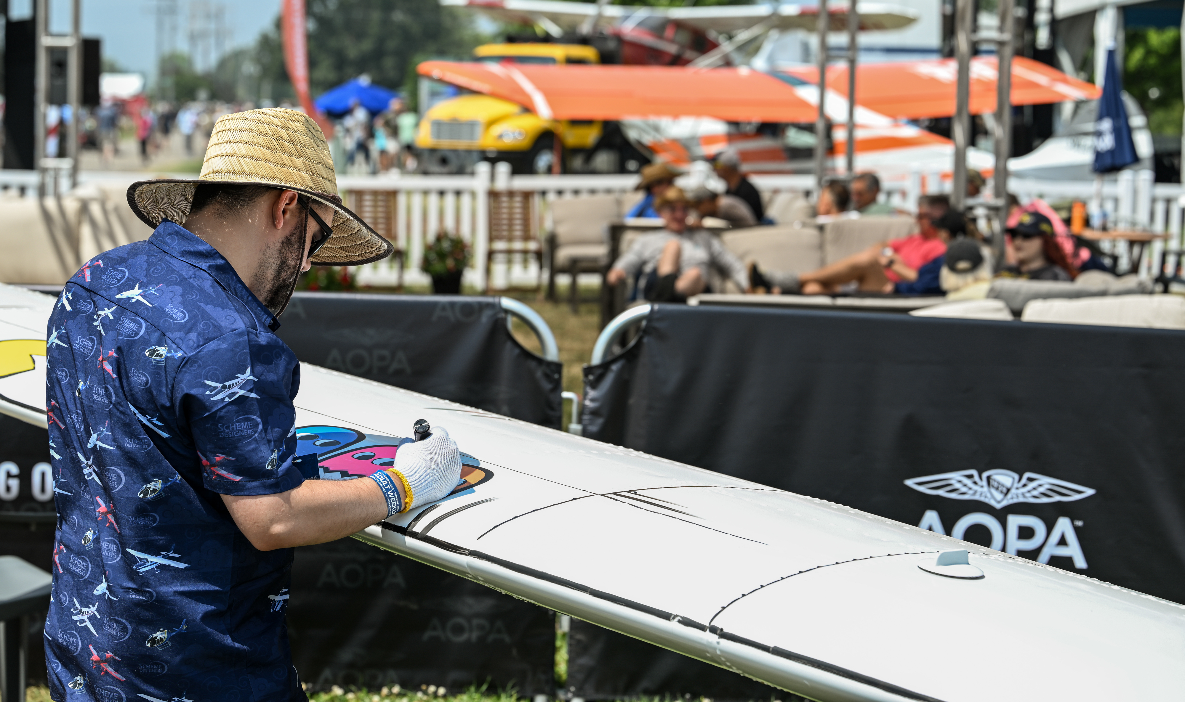 Noel Heckel of Scheme Designers planned to spend the week of AirVenture adding layers of color to the AOPA Sweepstakes Piper Archer. Attendees have opportunities to interact with the artist, who will work selected suggestions into the plan. Photo by David Tulis.