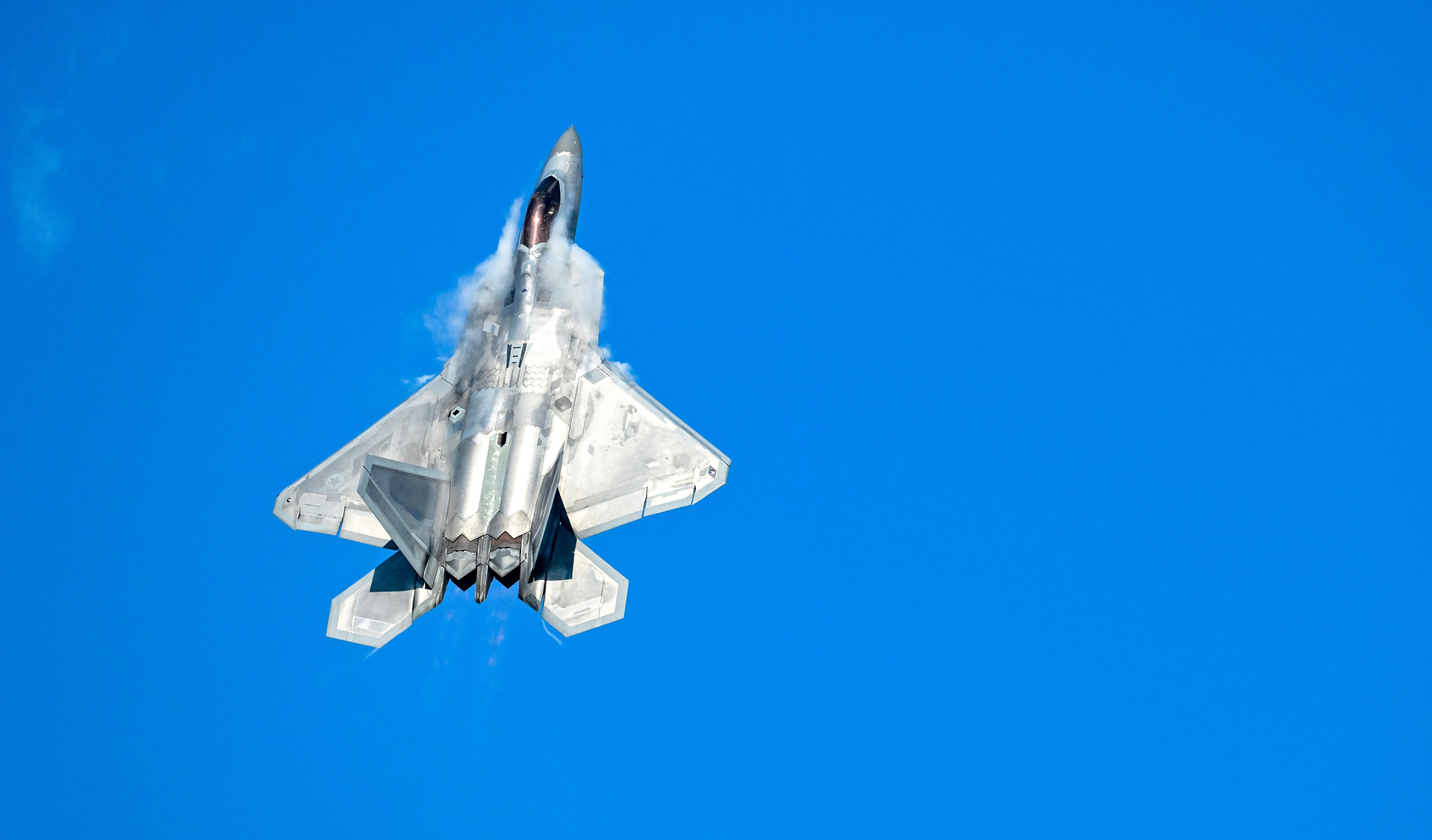 Condensation clouds emanate from the cockpit area of U.S. Air Force Lockheed Martin F-22 Raptor demo pilot Nick "Laz" Le Tourneau. Photo by David Tulis.