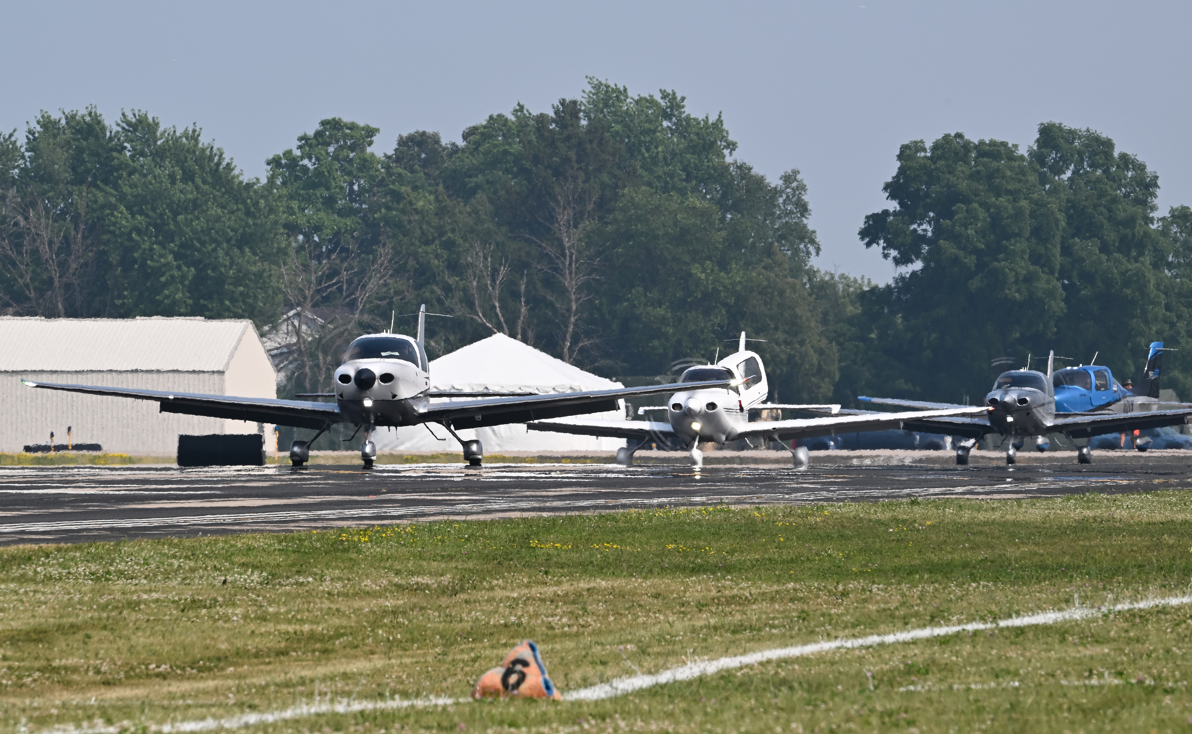 Pilots in the Cirrus Aircraft mass arrival taxi to parking on July 19. Photo by David Tulis.
