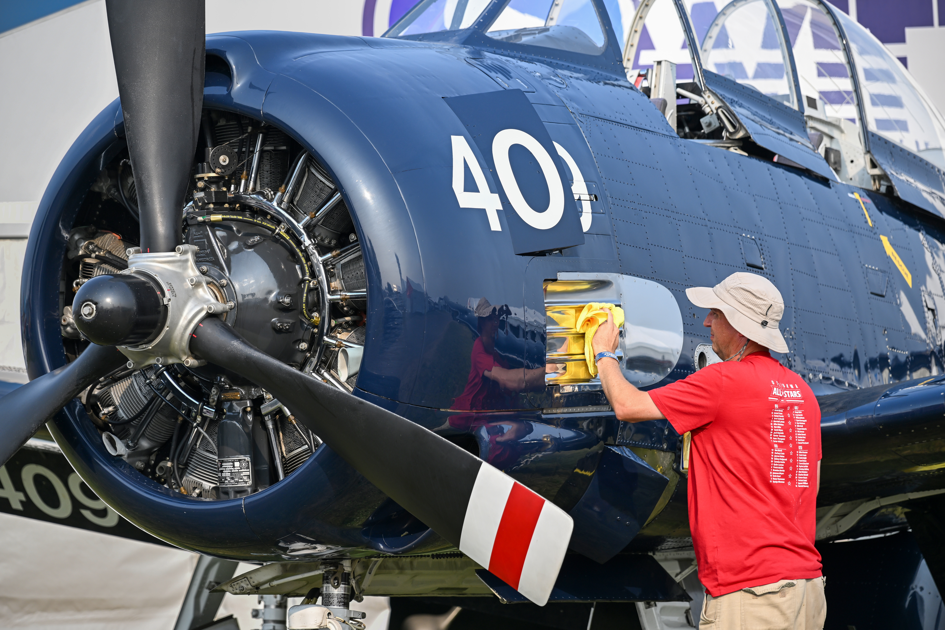 North American Aviation T-28 Trojan pilot Chris Birrell of Iowa polishes his aircraft on display at the Swift Fuels exhibit. Photo by David Tulis.