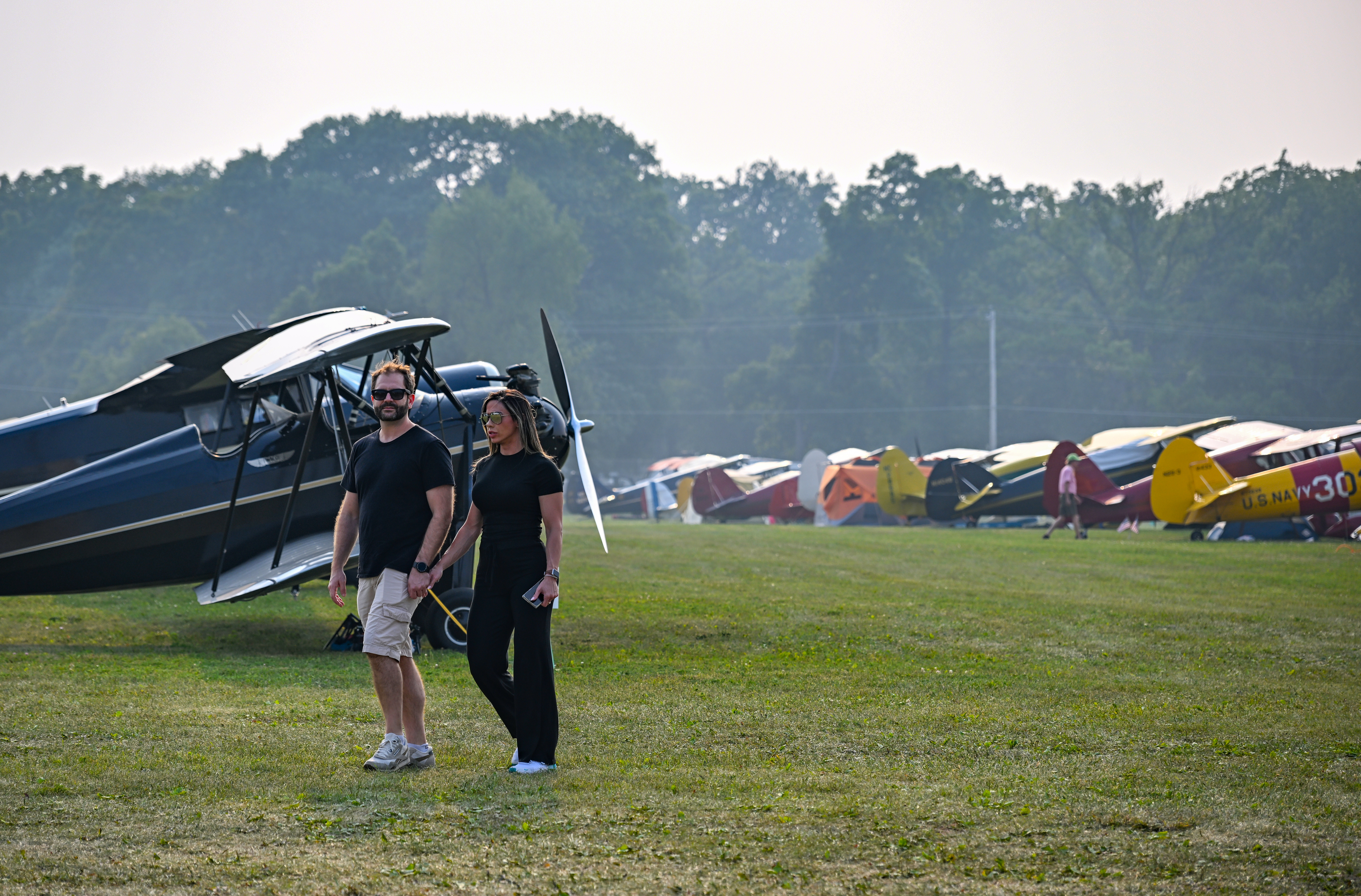 A couple walks past vintage aircraft. Photo by David Tulis.