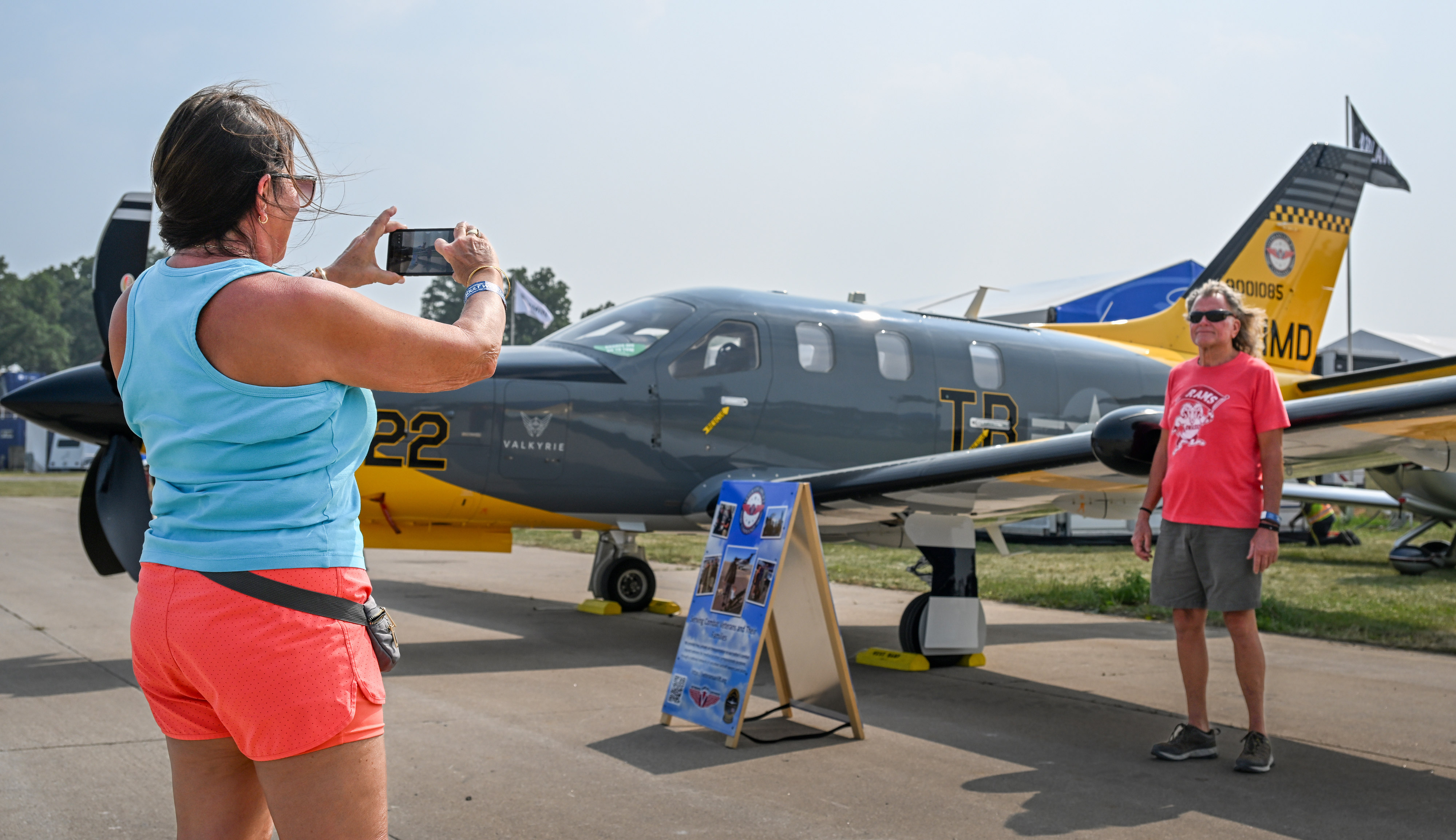A uniquely painted Daher TBM 900 aircraft known as "Valkyrie" honoring those participating in the Veterans Airlift Command makes its debut at Boeing Plaza and serves as the backdrop for Patrick Svoboda and Kathleen LaBonte of Kansas City. Photo by David Tulis.