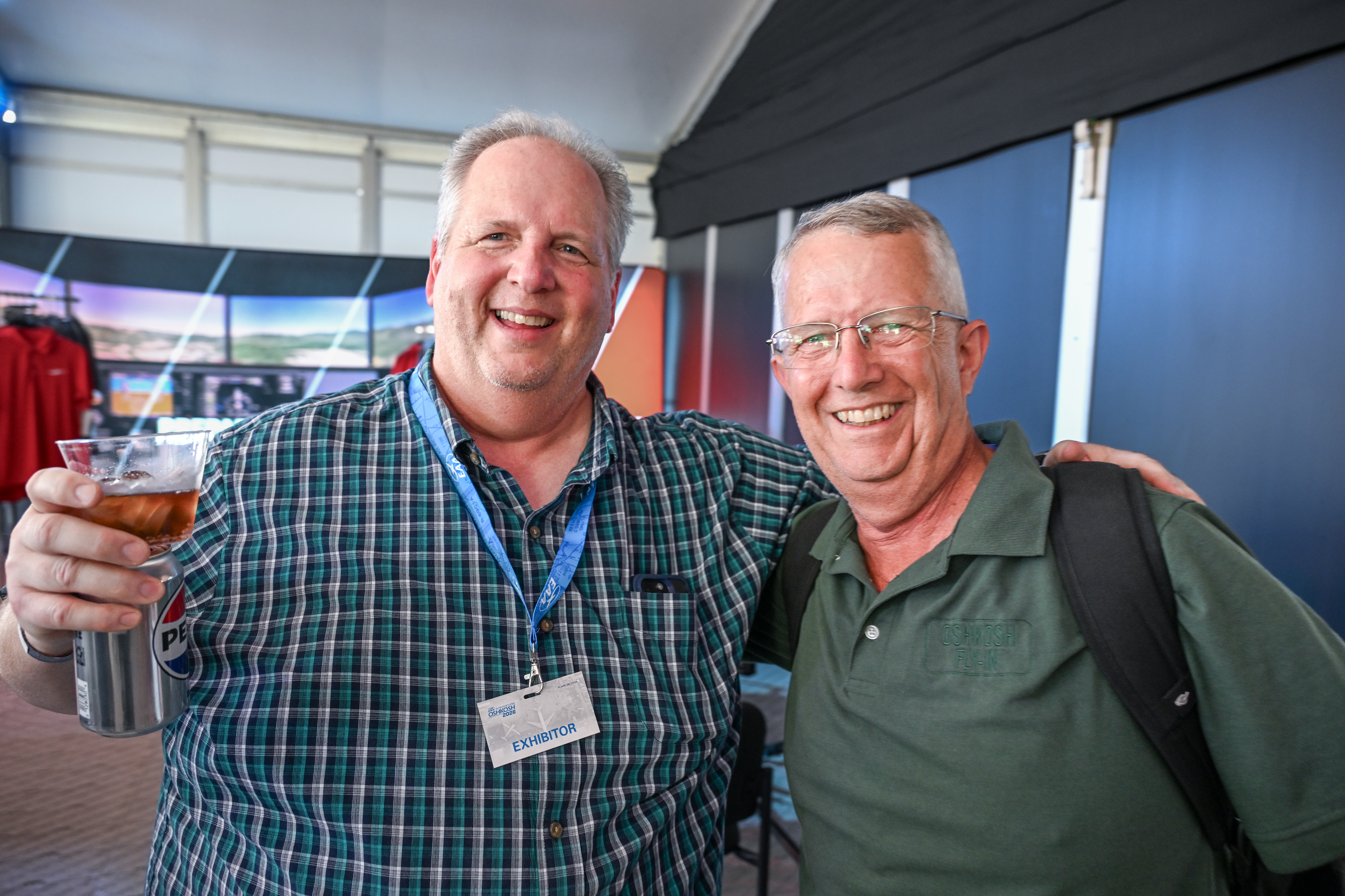 Brian Schiff of "The Schiff Show" greets 2026 National FAA Safety Team Representative of the Year Mike Jesch during a Redbird Flight Simulations welcome party on July 19. Photo by David Tulis.