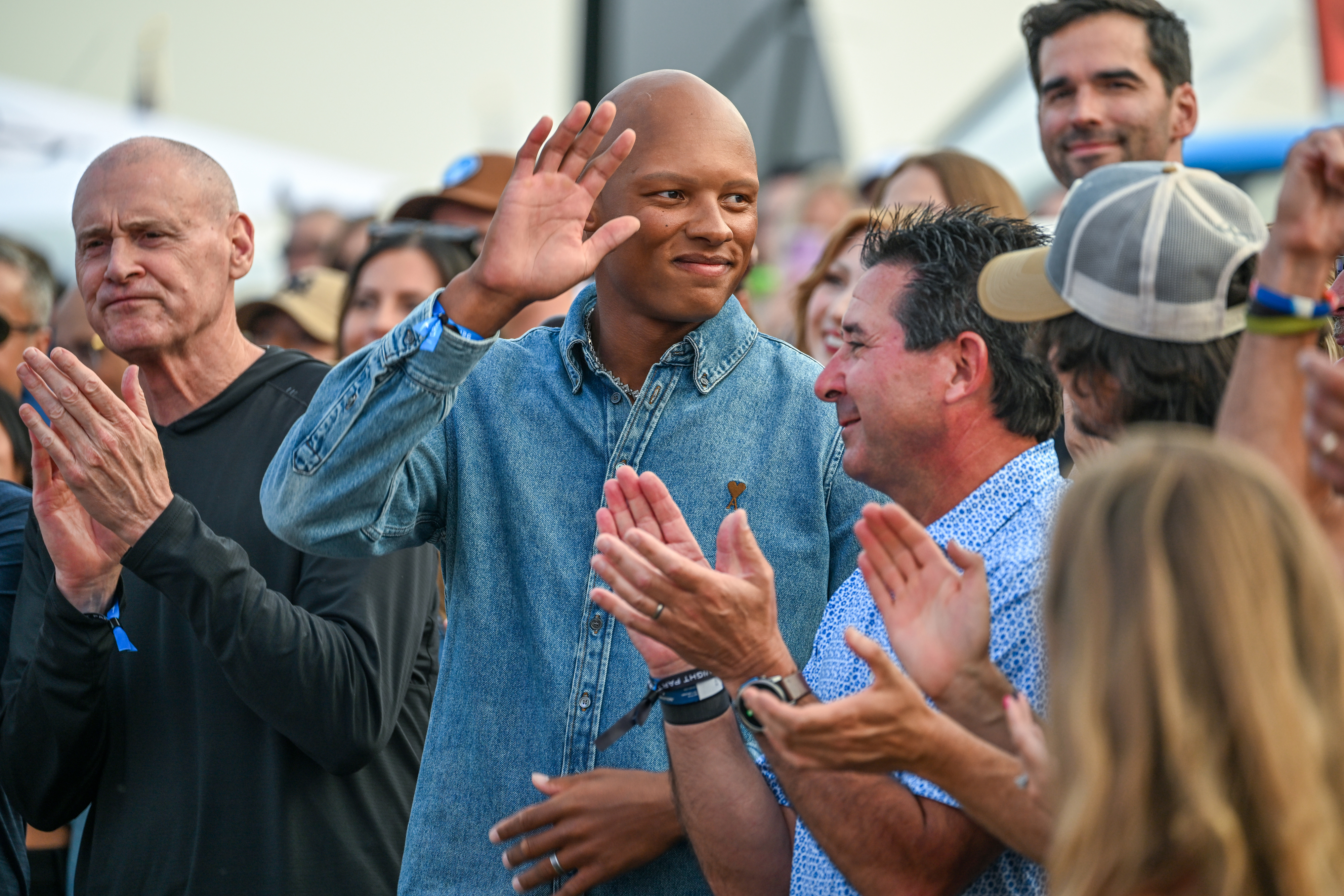 Cirrus Aircraft pilot, aerospace engineer, and NFL football player Josh Dobbs (center) joins airshow performer Michael Goulian and others as they are recognized at a welcome party. Photo by David Tulis.
