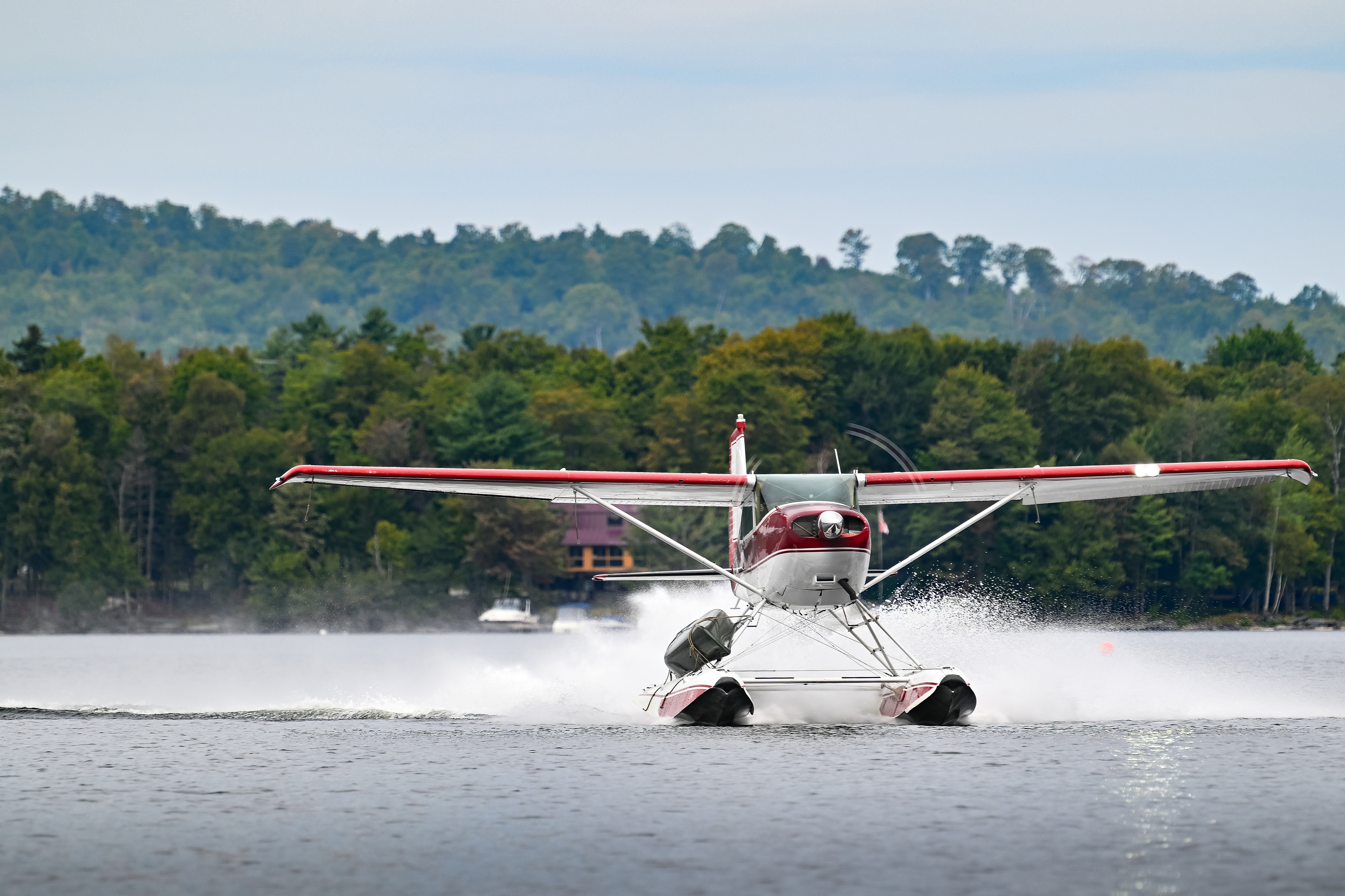 With the canoe safely lashed to a strut of the 1953 Cessna 180, Tommy Dunn step-taxis toward the finish line dock. Photo by David Tulis.