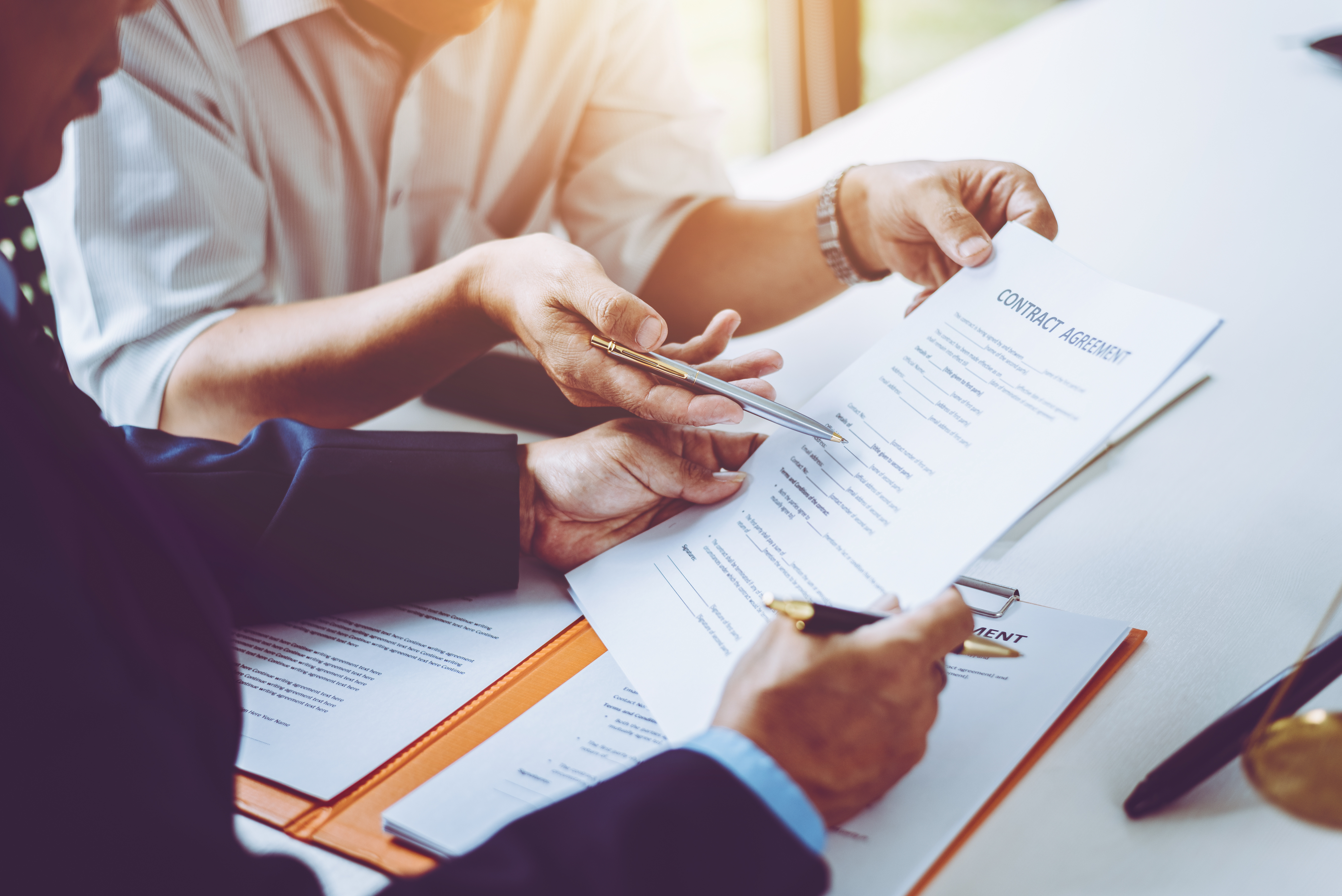 Group of middle age Asian business people and lawyers discussing and sign a contract in meeting room.