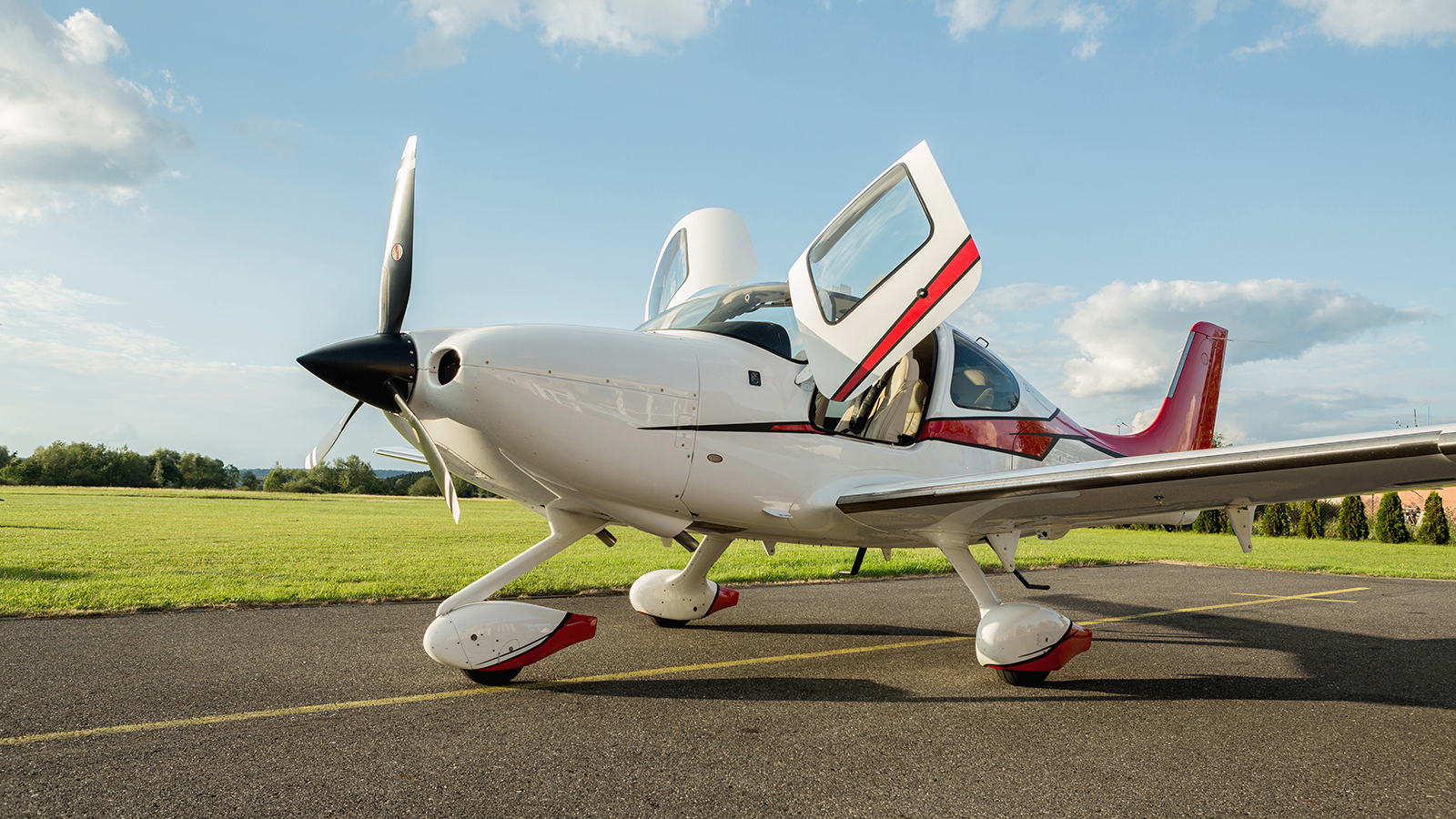 Single turboprop aircraft on the ground in sunny day, cirrus