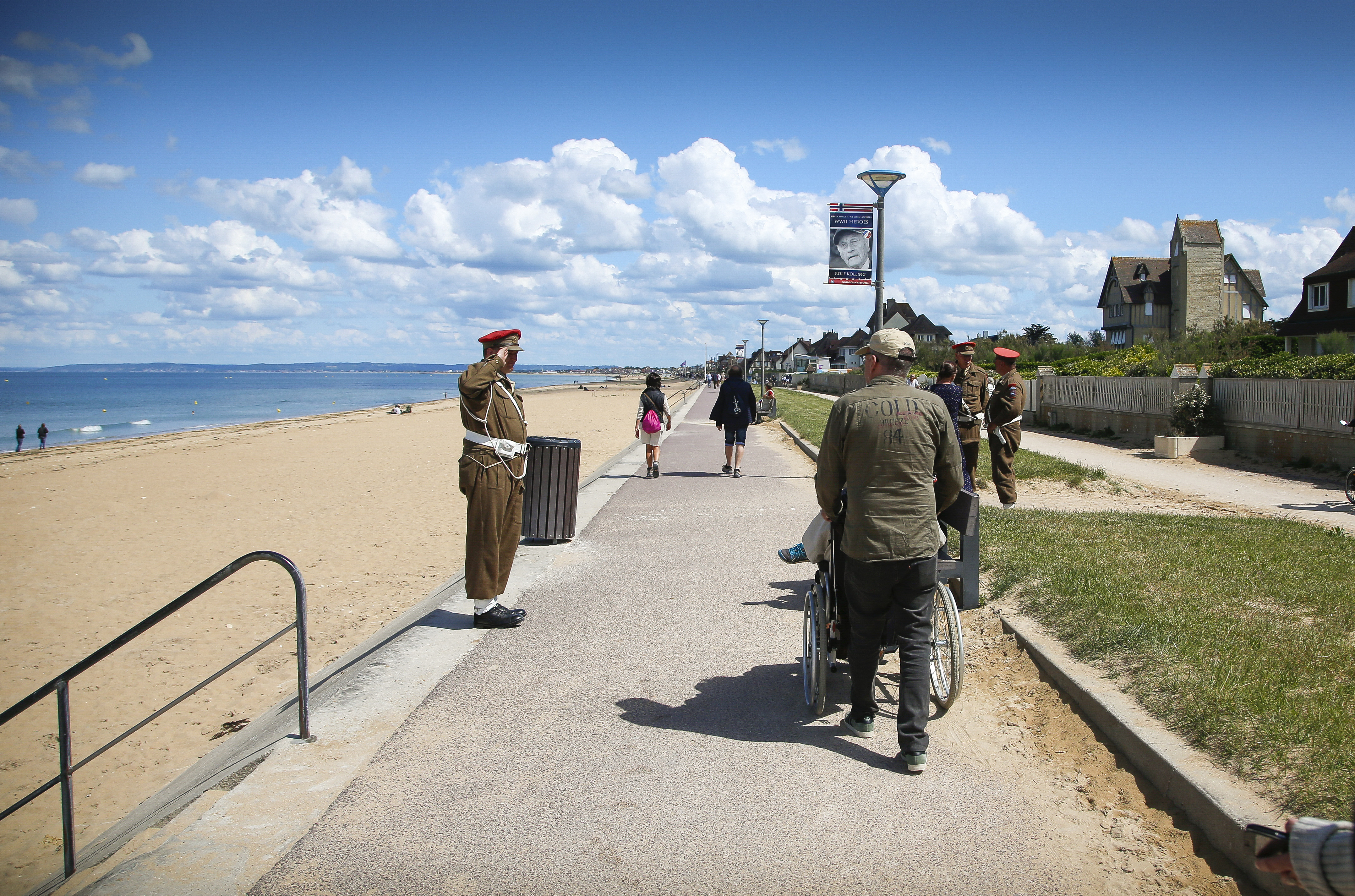 Reenactors salute a WWII veteran along Sword Beach.