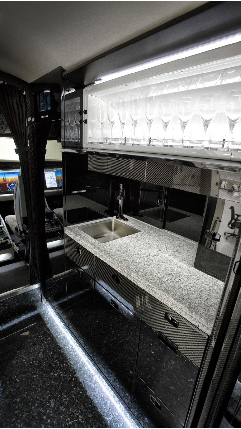 The galley, has convection and microwave ovens, an espresso machine, utensil and glassware storage, plus lockable cabinets and a granite-veneer floor.