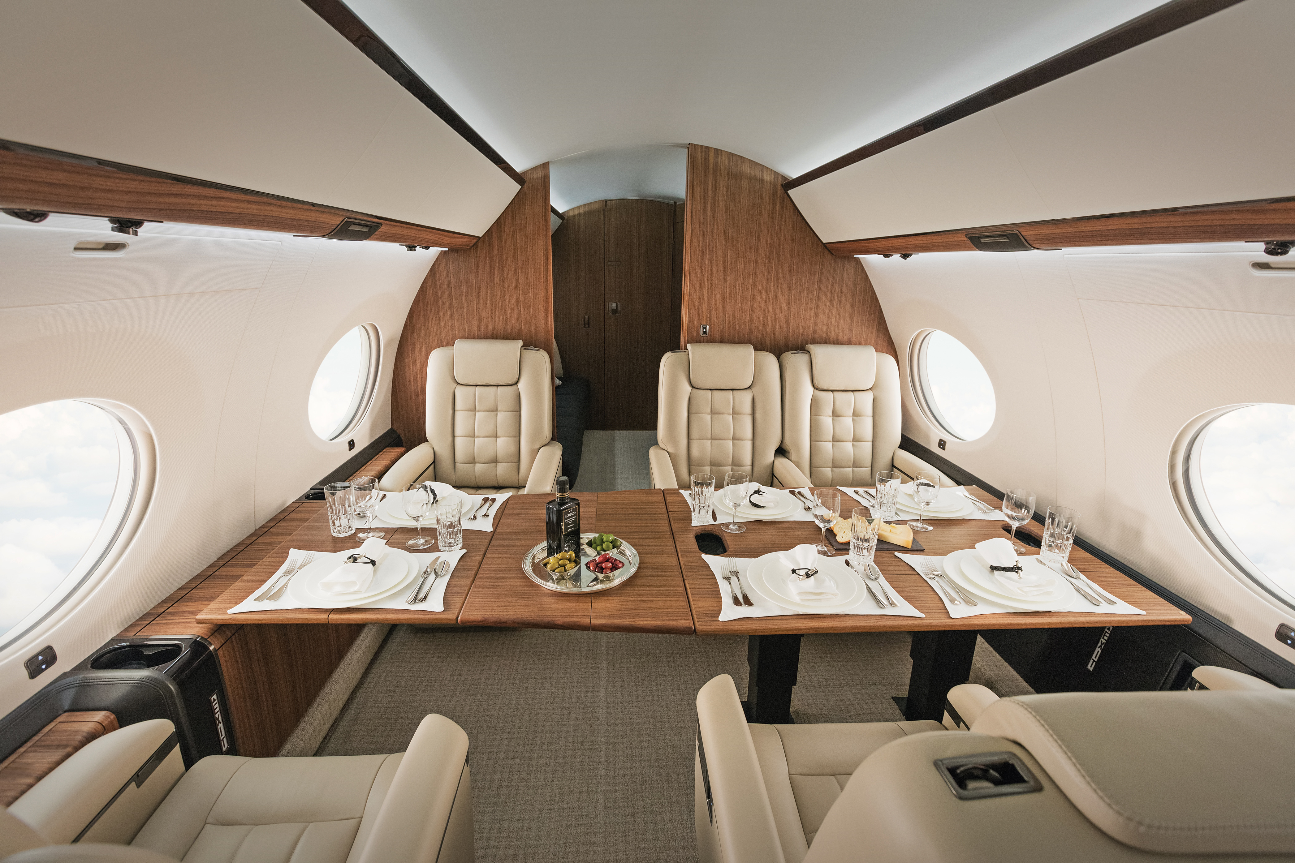 Cabins old and new. The clean, expansive dining zone of a Gulfstream G650, complete with Gulfstream’s signature oval windows. 