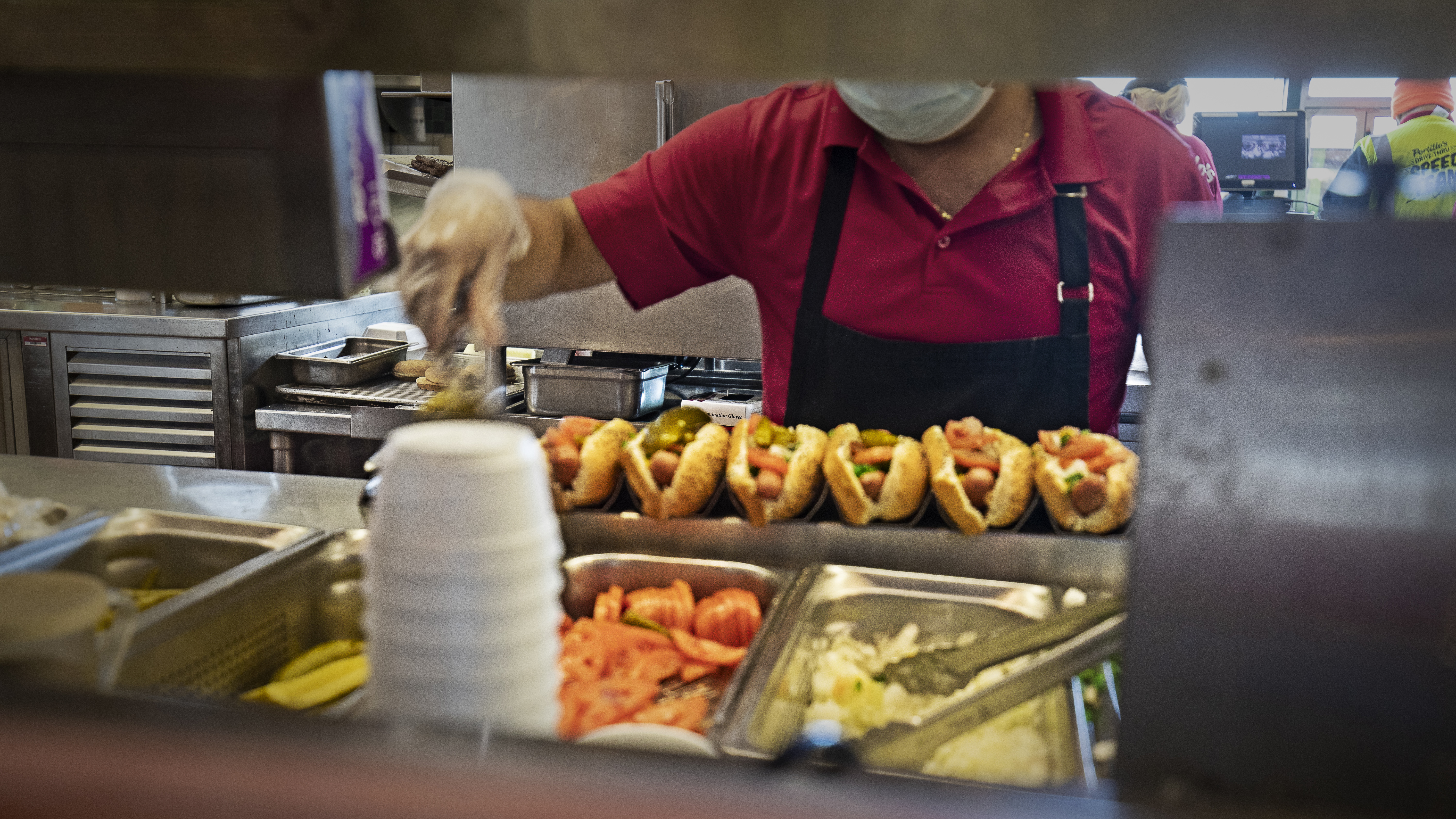 Hands a blur, a Portillo’s cook can make 10 Chicago-style hot dogs per minute.
