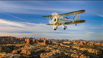 A WACO YMF–5D biplane overflies the remote “pinnacles” section of Canyonlands National Park with its distinctive, colorful rock formations. Photography by Chris Rose