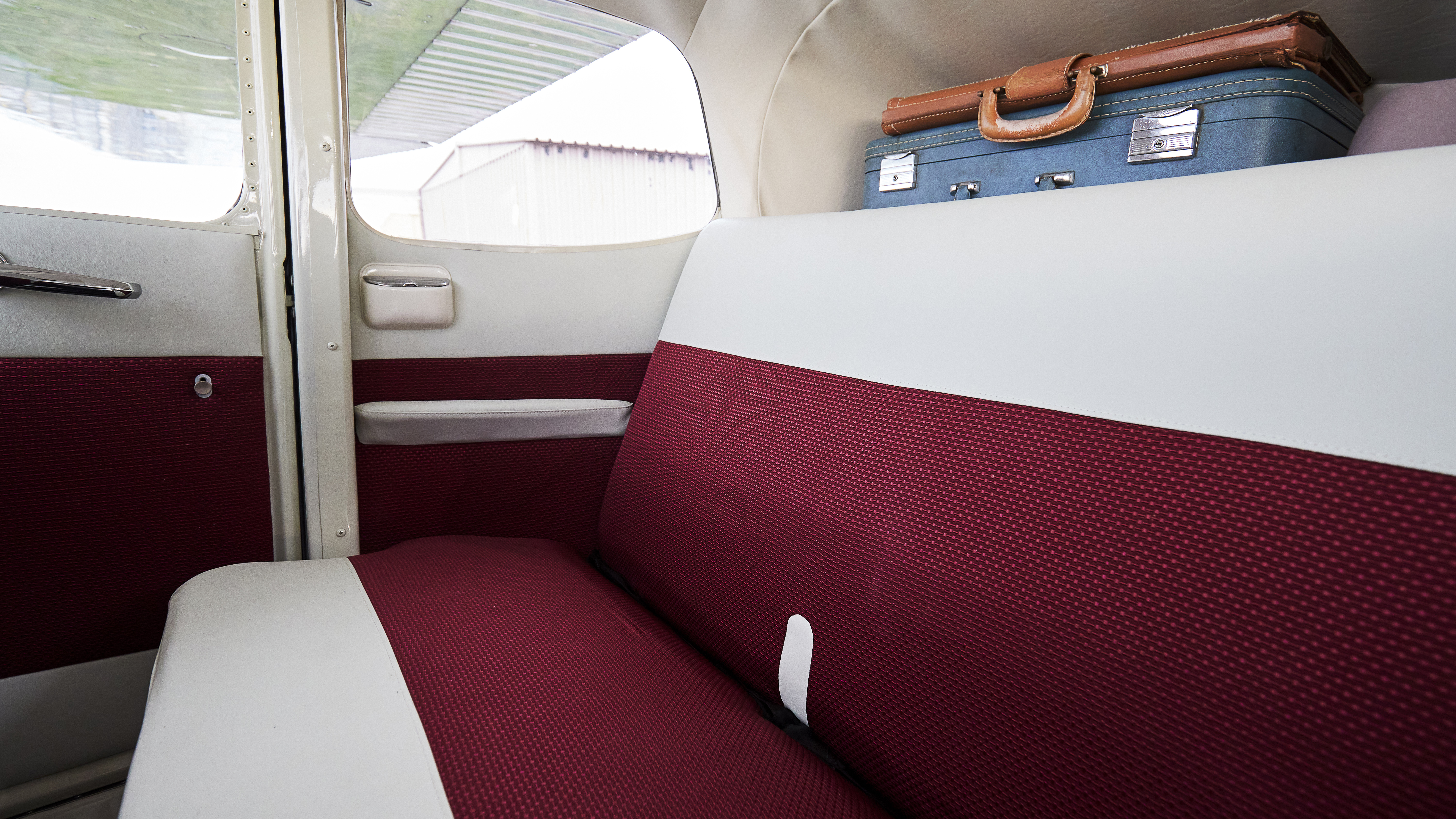 The rear compartment sports plush midcentury upholstery and vintage travel gear.