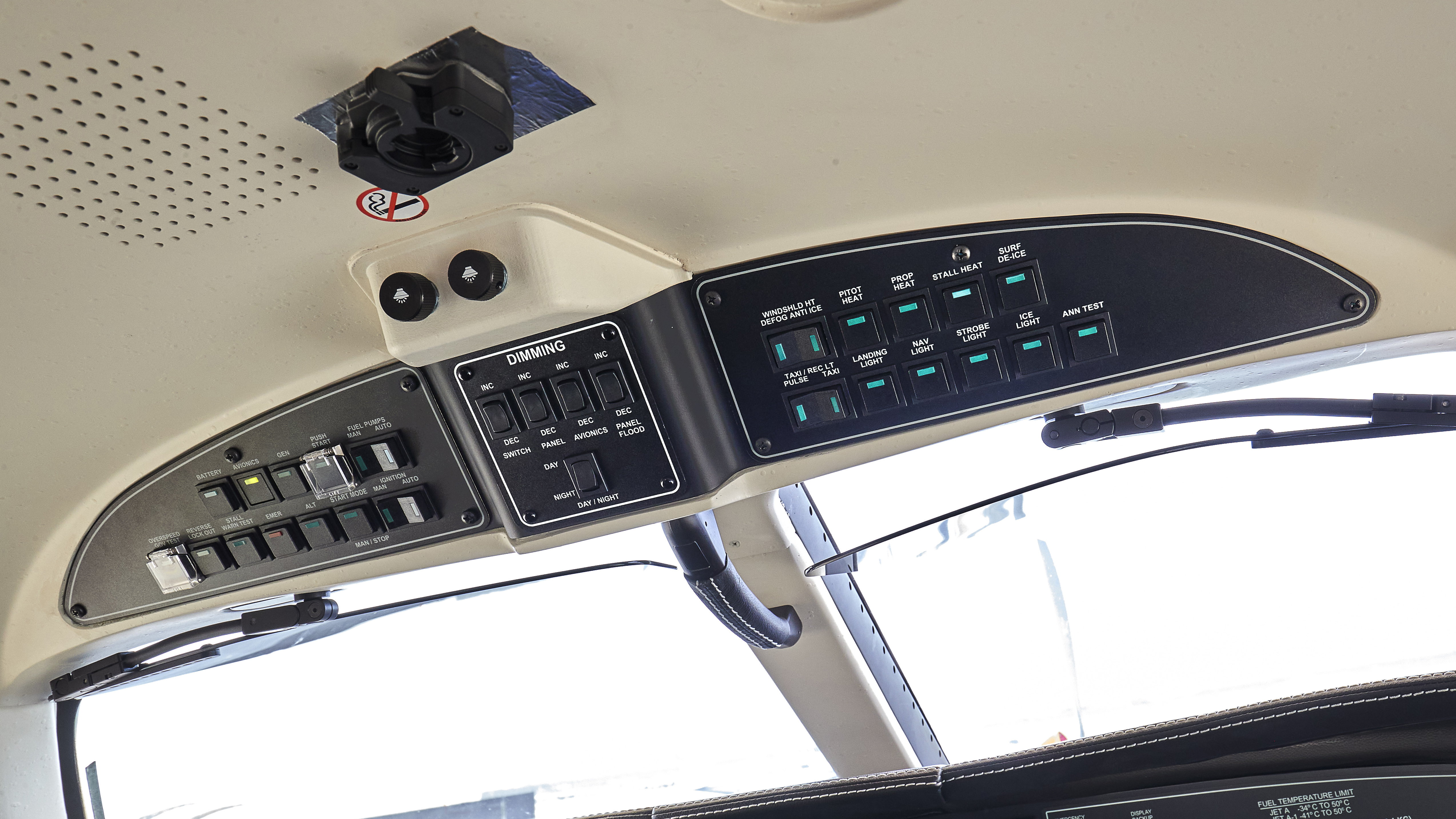The cockpit overhead panels contains, left to right, battery, avionics, ignition, and fuel pump switches; interior lighting switches; and ice-protection and exterior lighting switches.