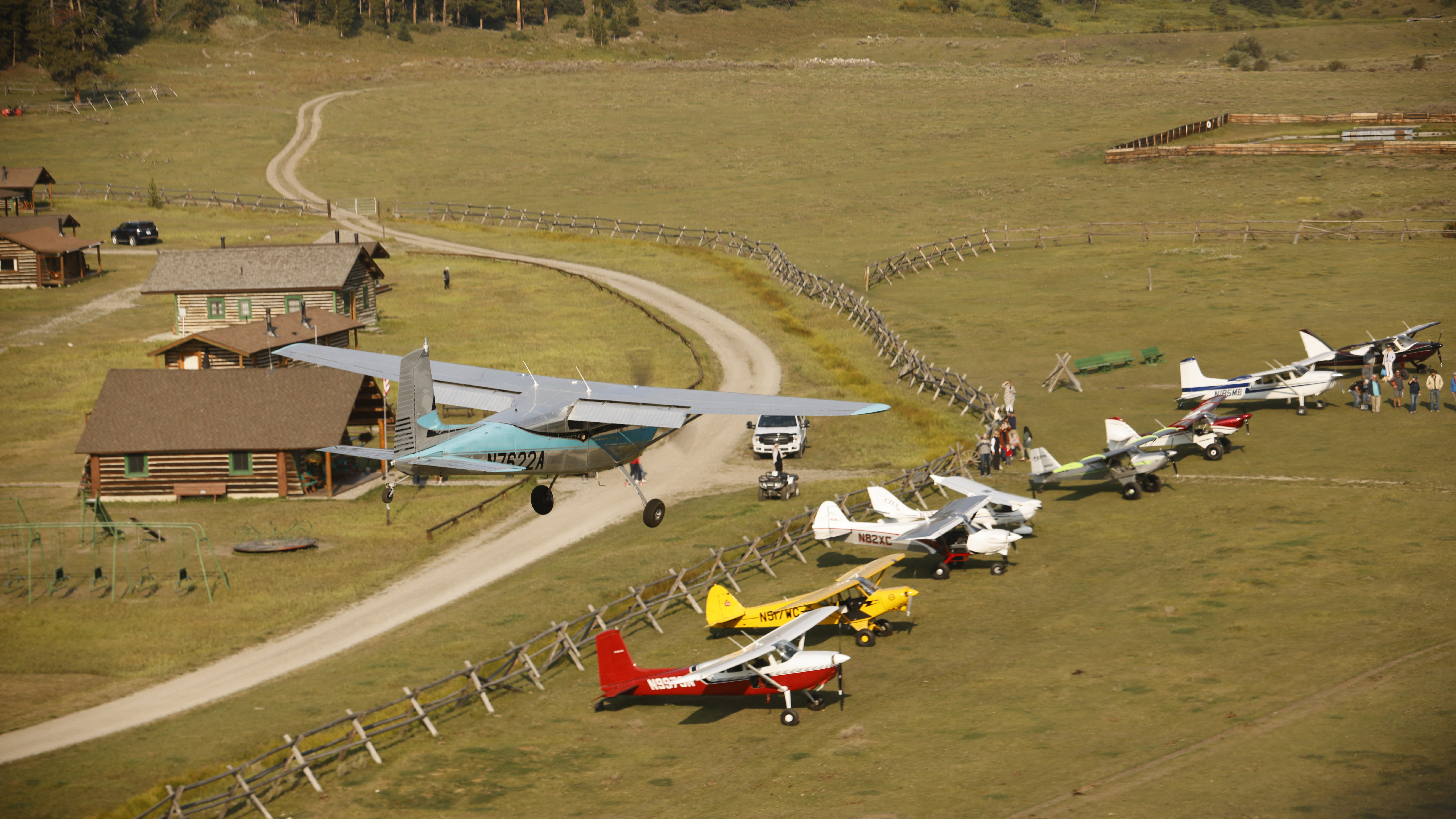 A Cessna 180 landing at the Nine Quarter Circle Ranch grass airstrip.