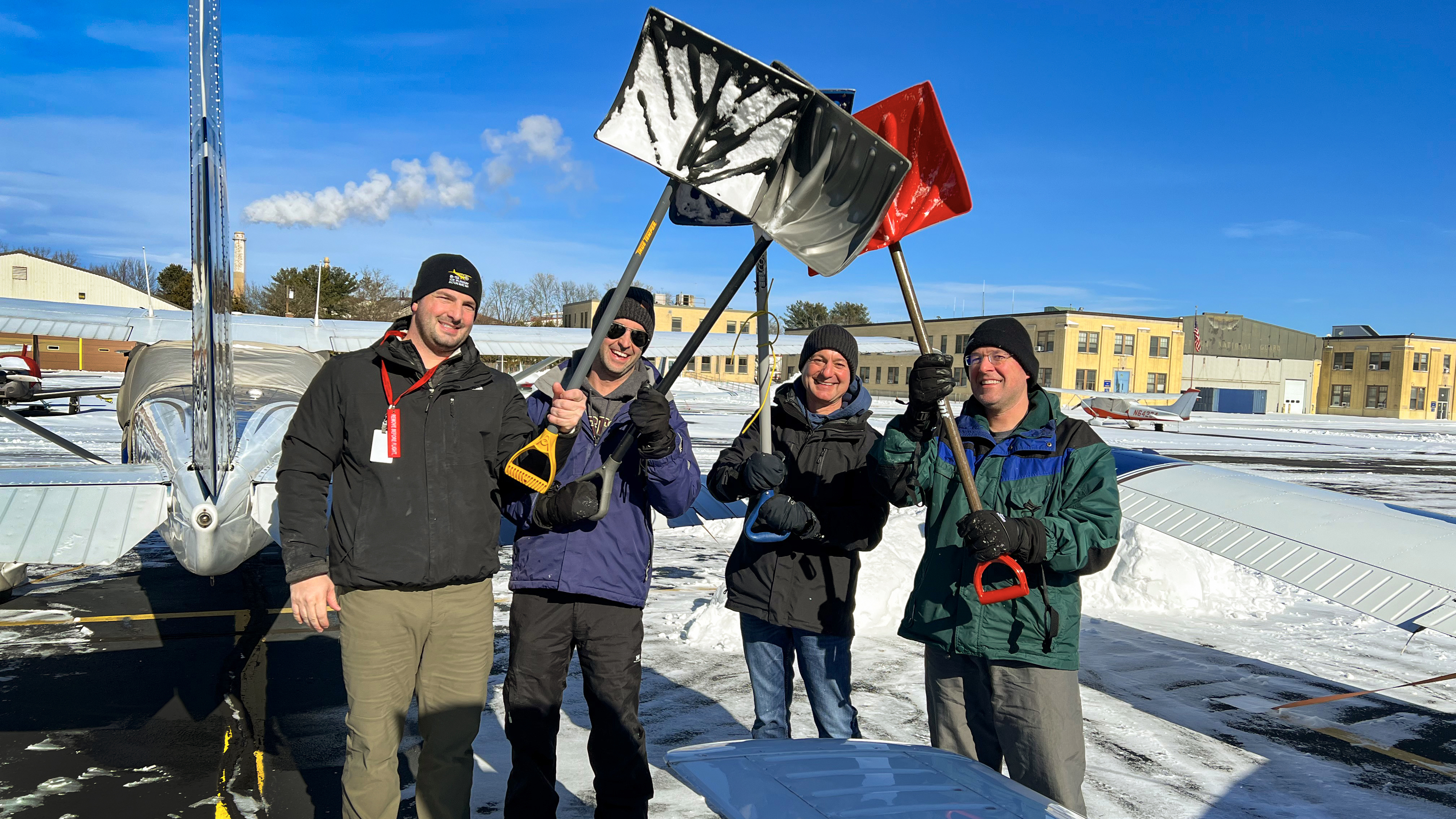 This flying club even has fun shoveling snow.