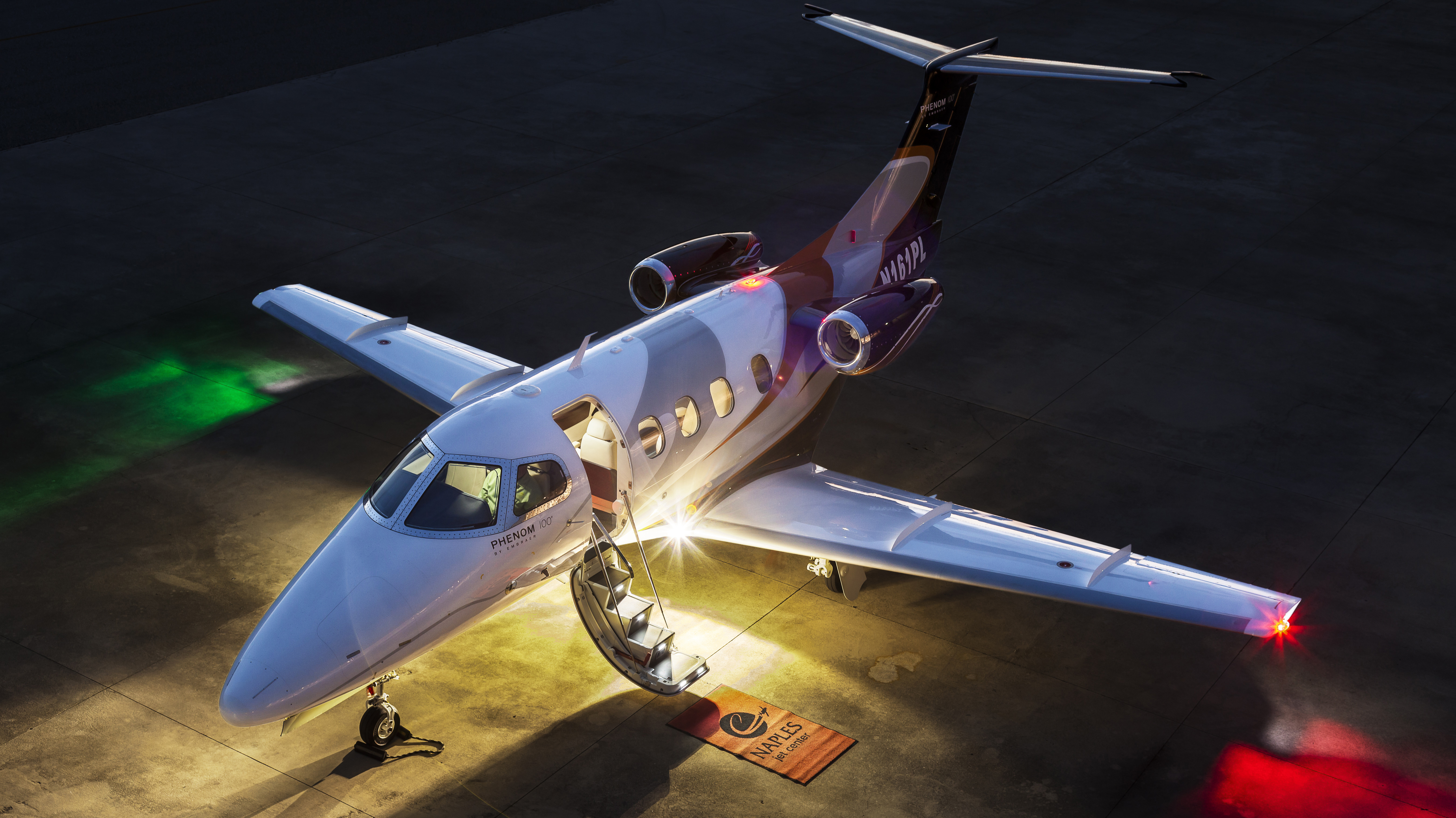 An Embraer Phenom 100, with lighted stairs and twin, telescoping handrails.