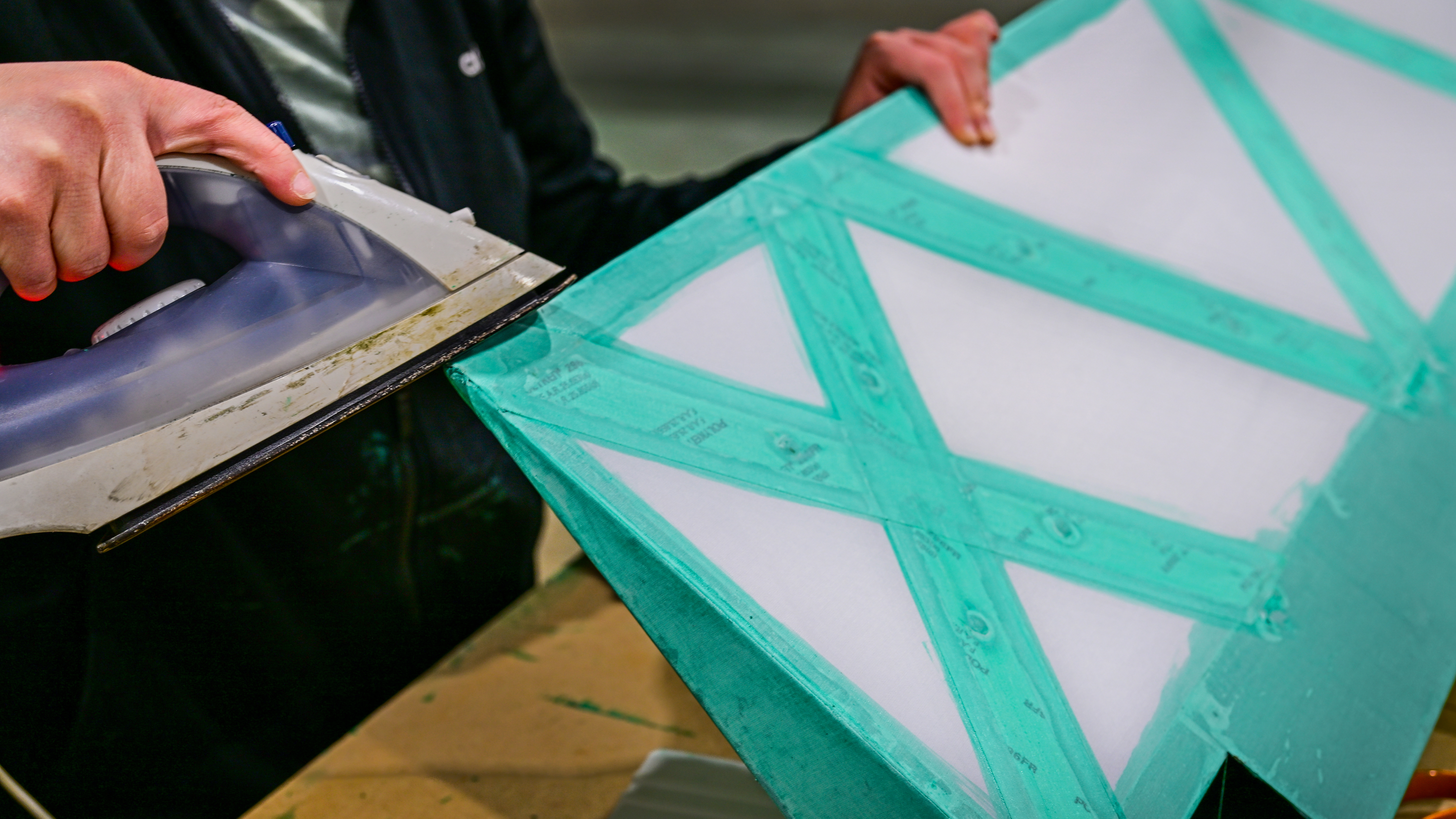 Employee Lauren Rohner irons fabric for an aileron.