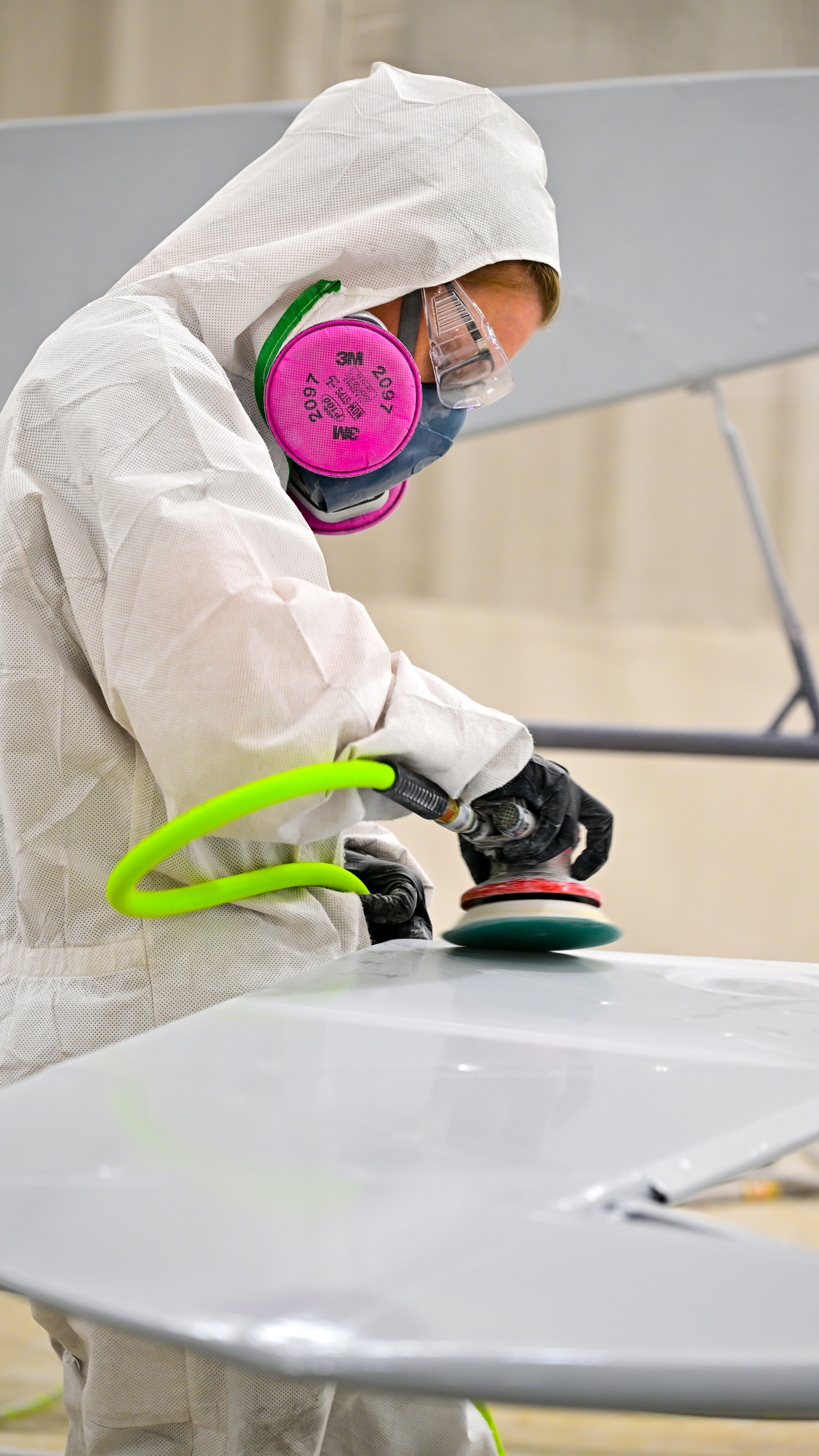American Champion Aircraft employee Kristina Hughen sands a rudder before additional paint is applied at the factory.