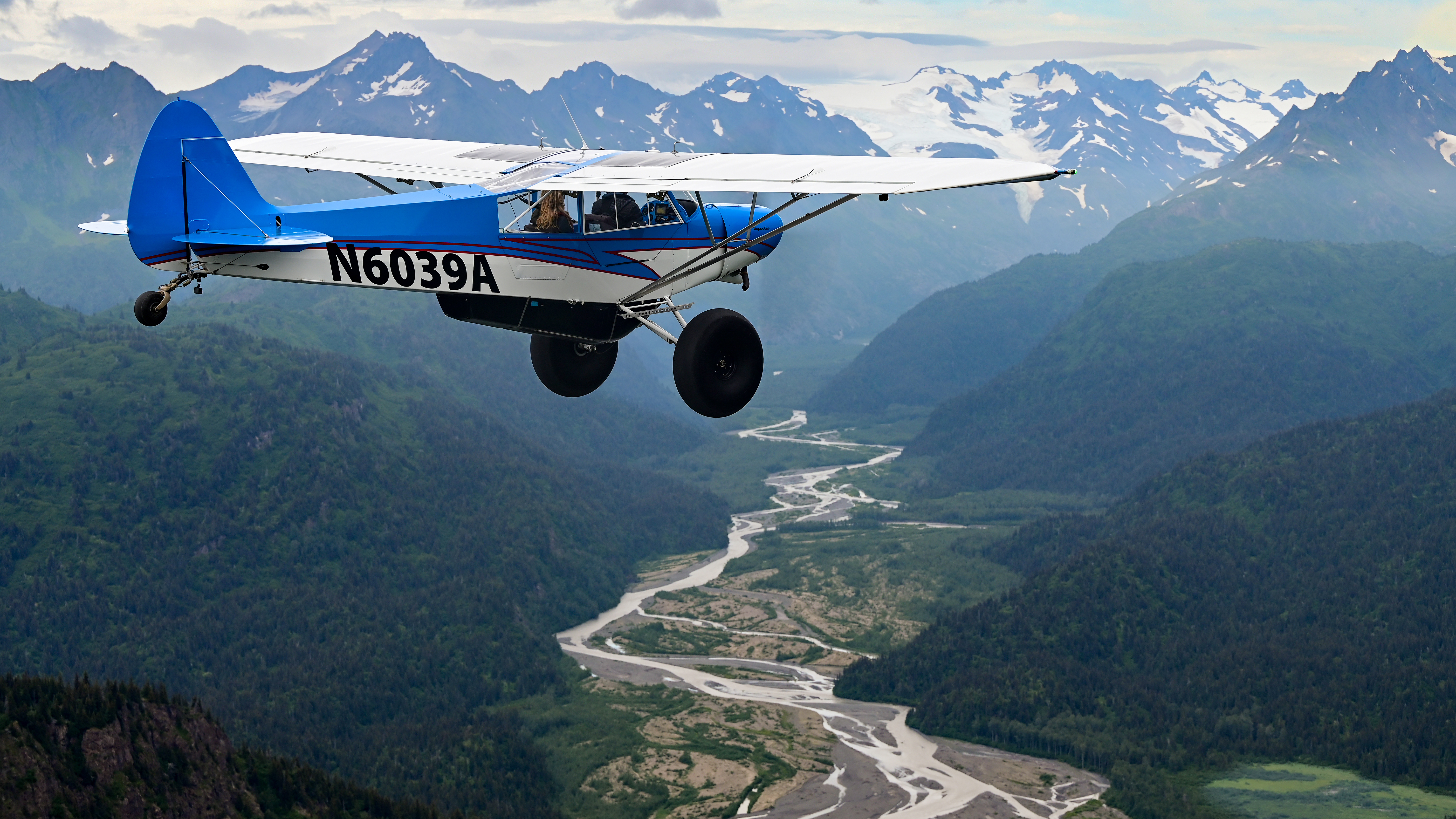 The mountains spill glacial runoff into the Pacific Ocean while their nearby peaks are shrouded in clouds at more than 18,000 feet.