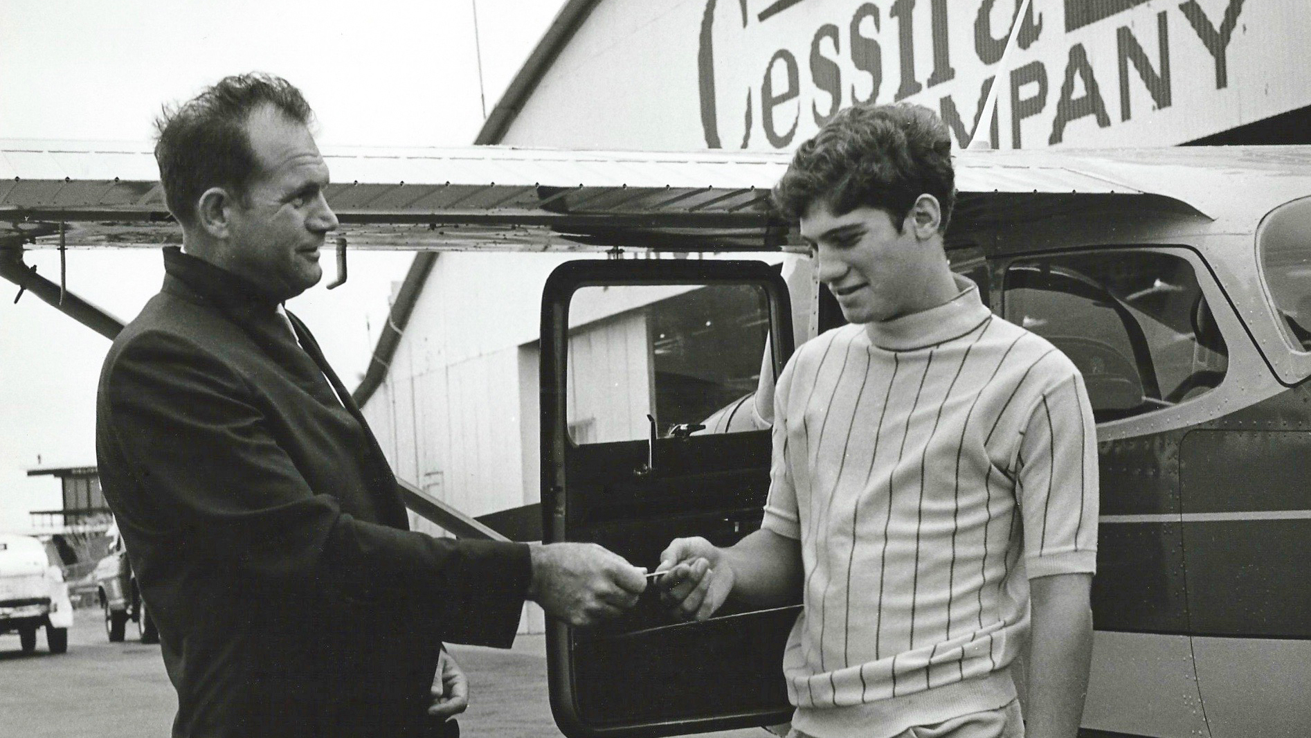Gene Ingram hands his son, Chris, the keys to a new Cessna to fly back to Carthage, Missouri, from Wichita, the day after Chris's sixteenth birthday. Photo courtesy of Sheila Harris