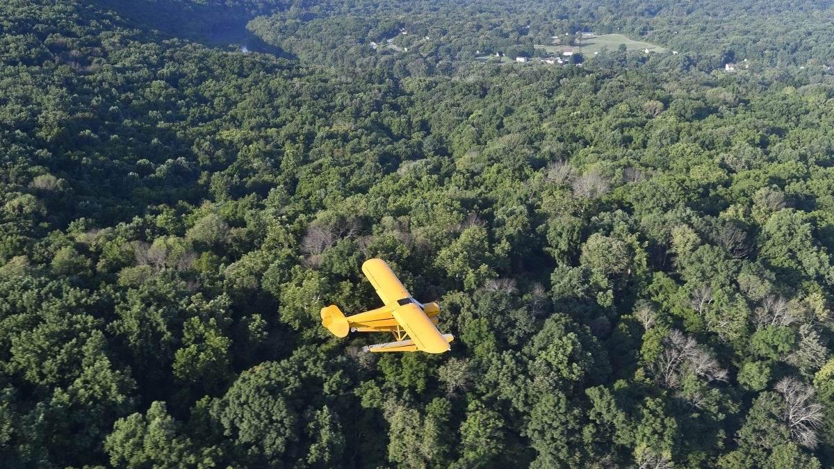 cub with floats flying over harpers ferry countryside