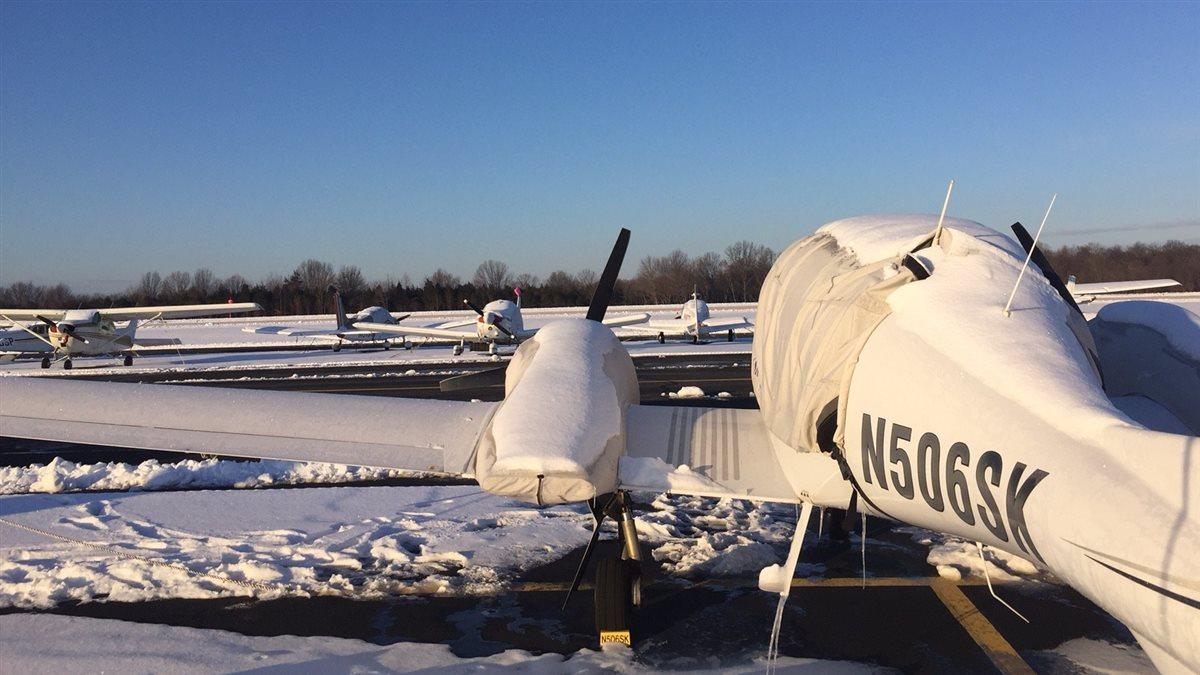 parked aircraft surrounded by snow