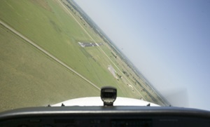 airplane in a turn with green field angled in view