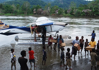 Volunteers and staff help unload medical supplies from Samaritan Aviation's Cessna 206 floatplane along Papua, New Guinea's Sepik River. Photo courtesy of Samaritan Aviation.