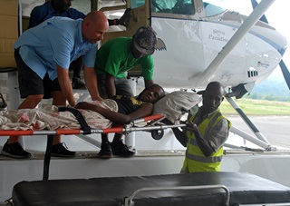 Samaritan Aviation's Mark Palm helps a patient from Kaunduwanum in Papua, New Guinea. Photo courtesy of Samaritan Aviation.