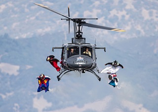 Competitors begin their wingsuit flights from a helicopter during the Red Bull Aces, a wingsuit four-cross race, over Cloverdale, California. Defending champion Andy Farrington of the United States was victorious in the race that pits four competitors flying by aerial gates suspended by helicopters. Joerg Mitter/Red Bull Content Pool.